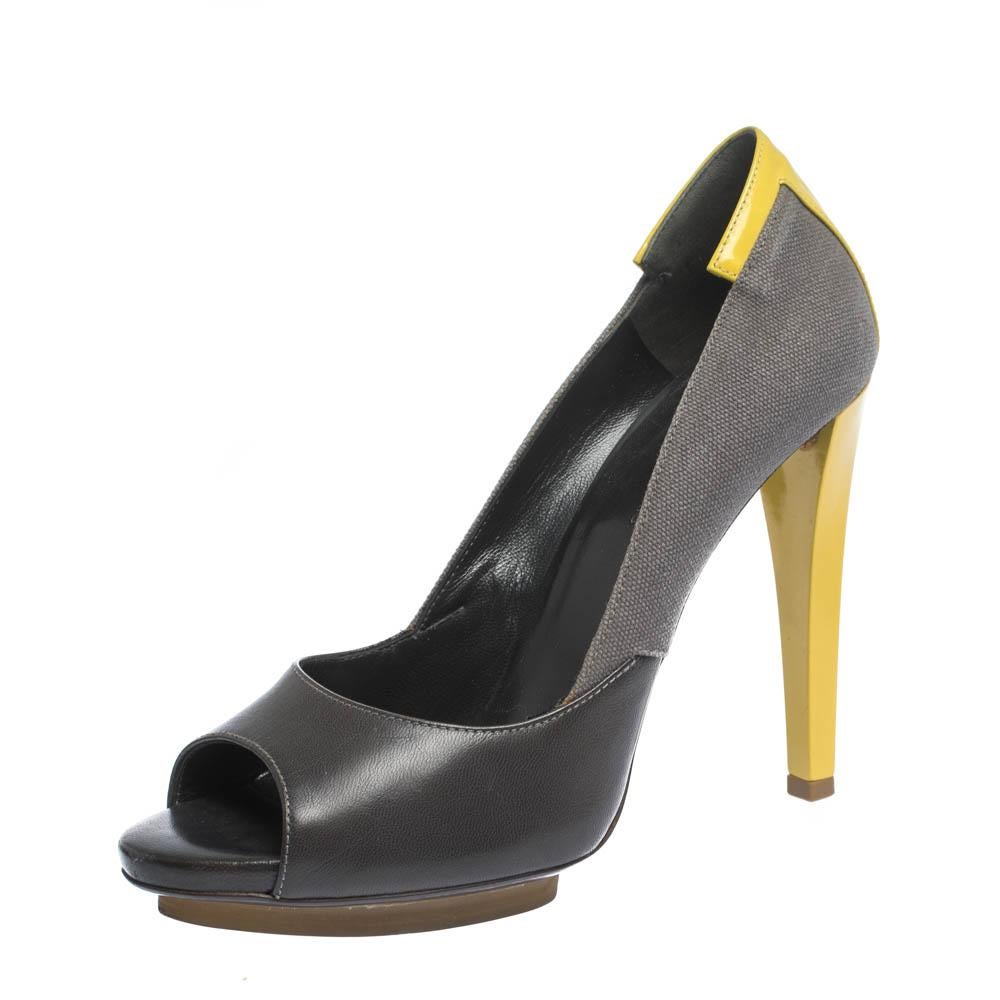These stylish and striking pumps come from the house of Balenciaga. Crafted from quality canvas & leather, they come in lovely hues of grey & yellow. They are styled with open toes, sculpted top line, contrasting heels that stand at 11.5 cm heels