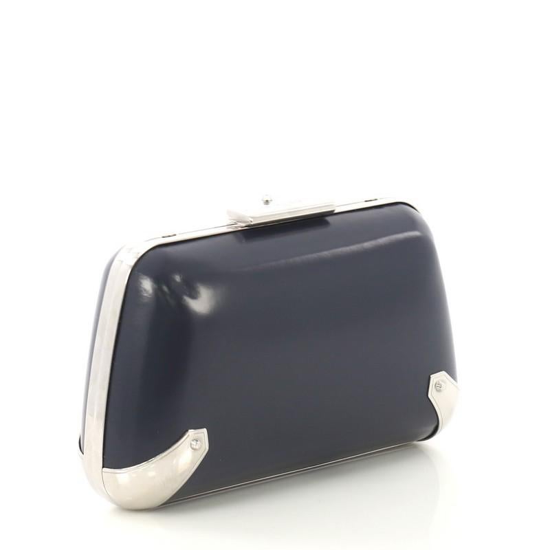 This Balenciaga Hard Case Clutch Leather with Metal Detail Small, crafted from navy leather, features a long shoulder strap, metallic trim, bracket detailing at the corners, and silver-tone hardware. Its push lock closure opens to a navy suede