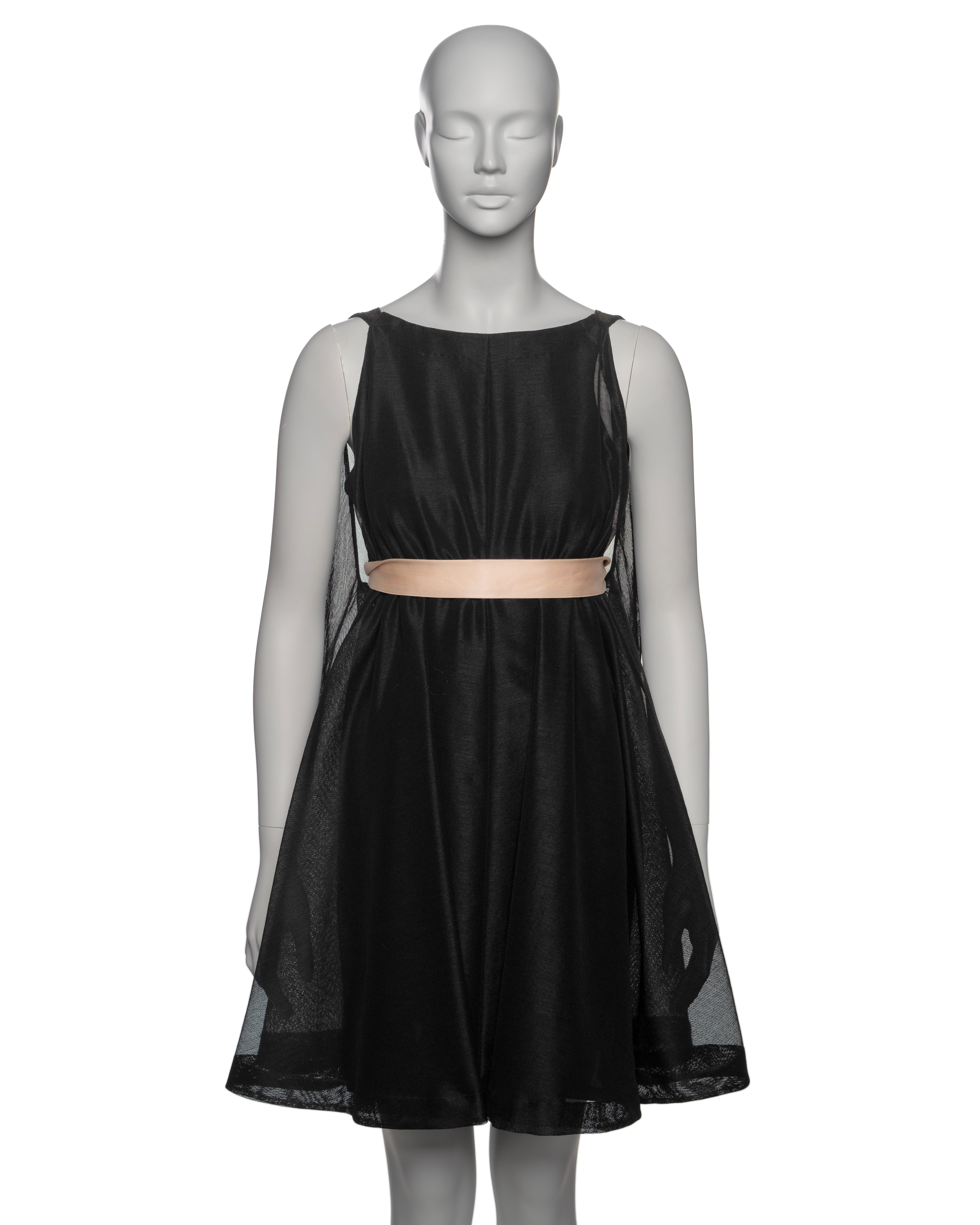 Abito da sera Balenciaga Haute Couture squisitamente realizzato in marquisette nera tagliata in sbieco, un tessuto a rete fine e aperta che conferisce al design una qualità ariosa e delicata. L'abito presenta una classica silhouette ad A con una