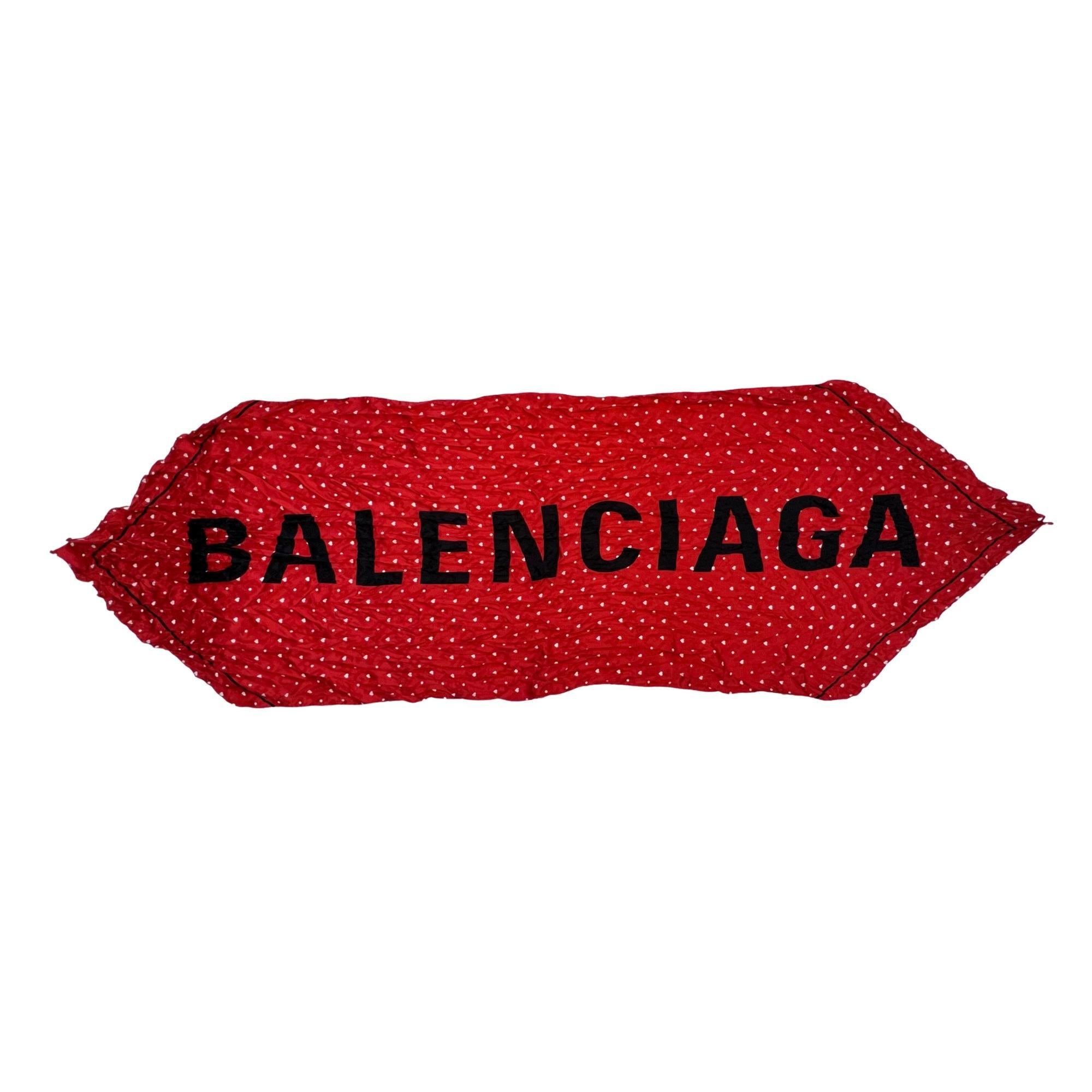 Dieser Schal ist aus leicht gekräuselter roter Seide mit einem lebhaften weißen Jacquard-Print und dem Balenciaga-Logo in großen schwarzen Buchstaben gefertigt. Knüpfen Sie ihn durch Ihren Pferdeschwanz, den Riemen Ihrer Lieblingstasche oder in das