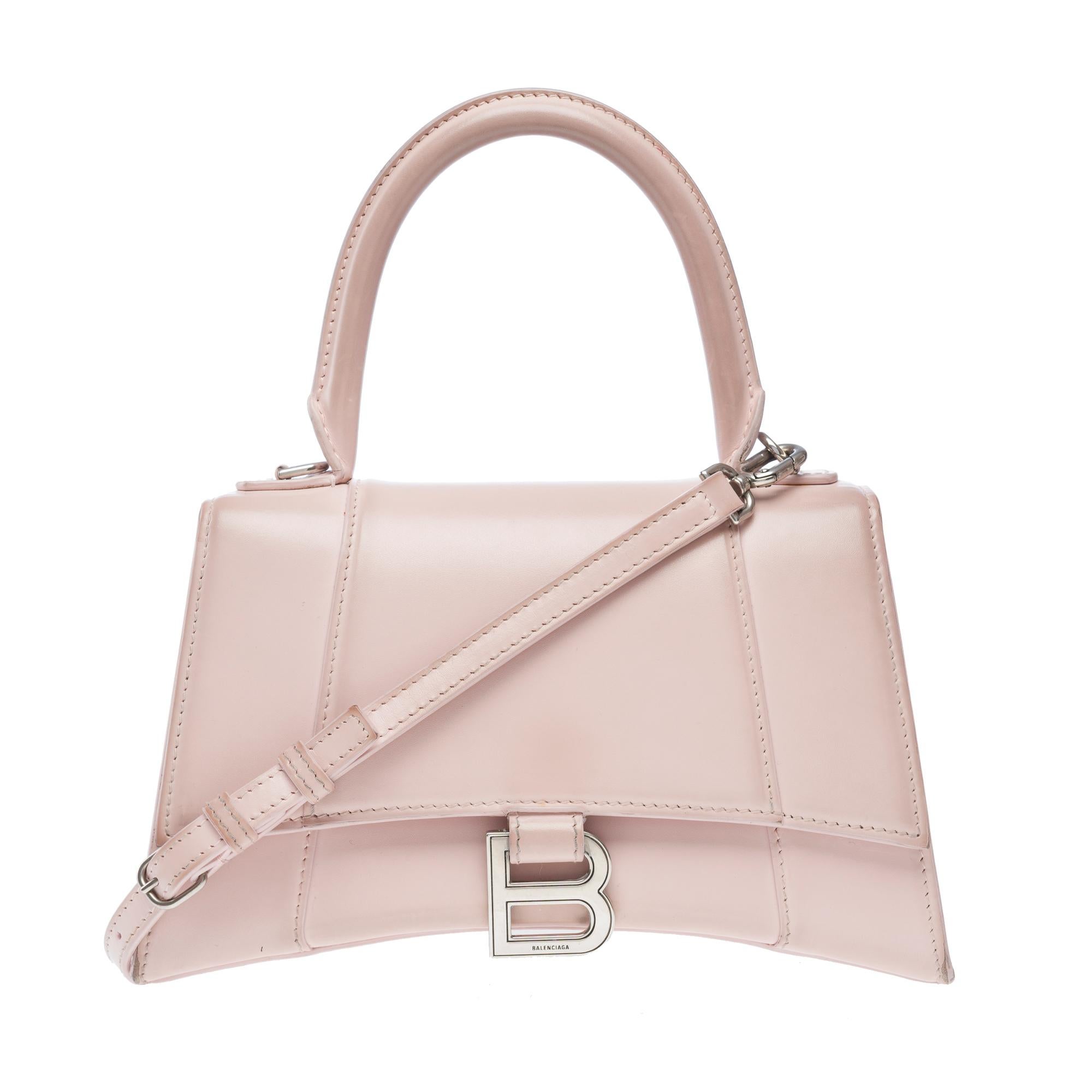 Elegante borsa Balenciaga Hourglass Small Box in pelle di vitello rosa, finiture in metallo argentato, manico singolo in pelle rosa e tracolla rimovibile e regolabile per indossarla a mano, a spalla o crossbody.

Chiusura magnetica con marchio I. A.
