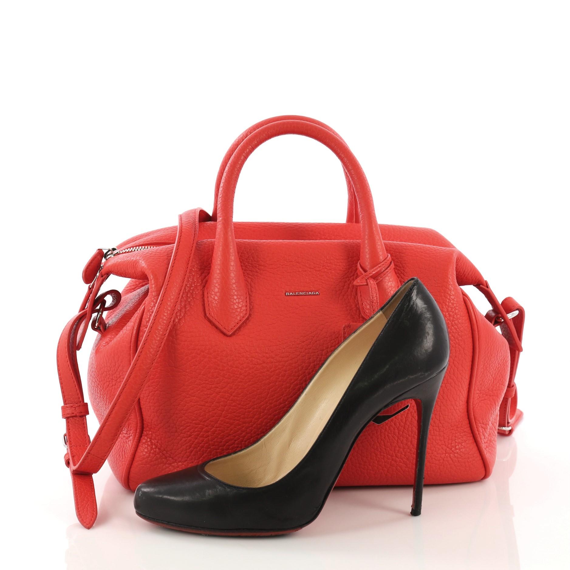 This Balenciaga Infanta Boston Bag Leather Small, crafted from red leather, features dual rolled handles, raised logo at its front, and silver-tone hardware. Its top zip closure opens to a black fabric interior with side zip pocket. **Note: Shoe