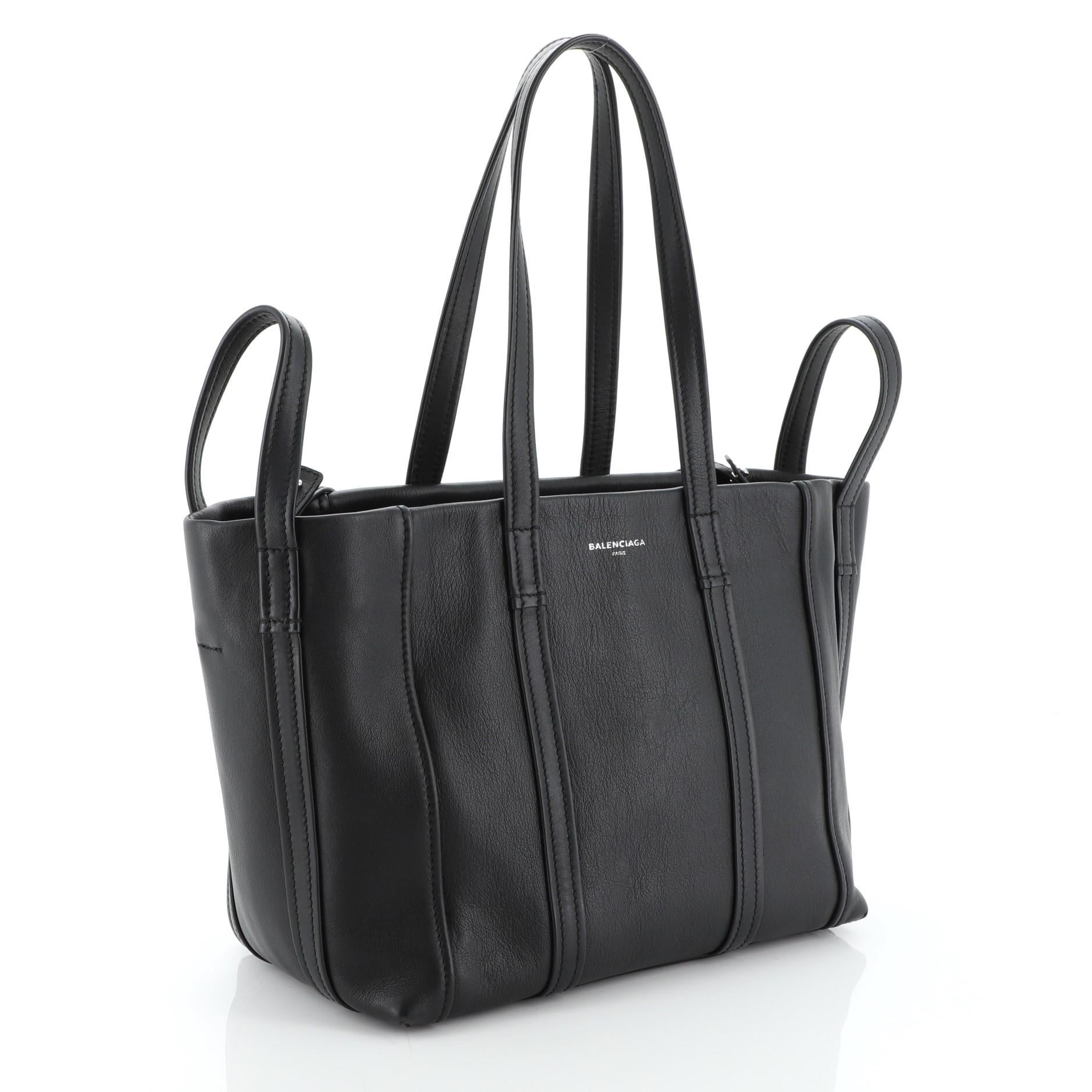 This Balenciaga Laundry Cabas Tote Leather Medium, crafted in black leather, features twin top handles and silver-tone hardware. It opens to a black leather interior with zip pocket. 

Condition: Very good. Slight creasing near base, minor wear on