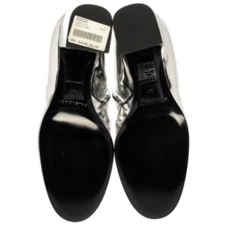 Ajoutez une touche structurée et glamour à votre tenue avec ces bottes de Balenciaga. Ces bottines sont réalisées en cuir verni argenté métallisé et présentent une silhouette épurée. Ces beautés rehausseront n'importe quel look avec un impact
