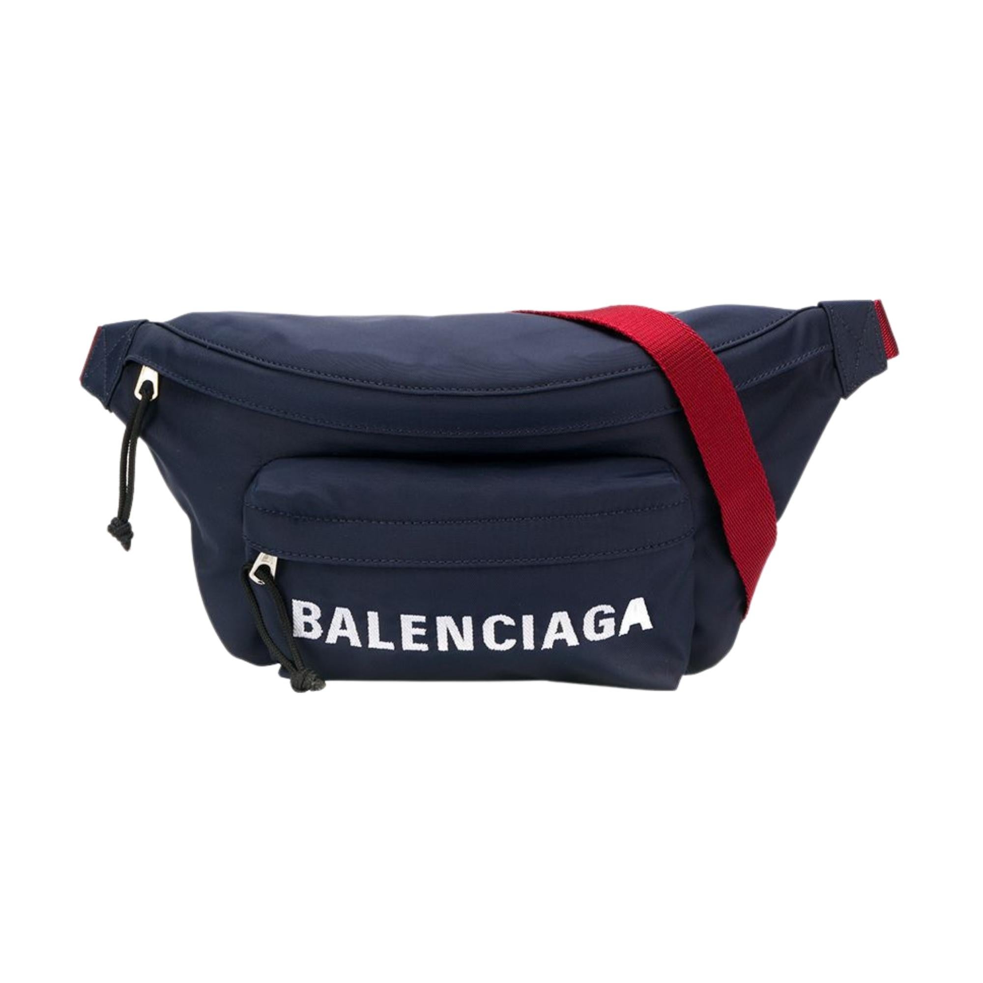 The fanny pack features a navy polyester exterior, a red woven fabric adjustable belt, an embroidered logo on the front pocket and two compartments with zip closure.

COLOR: Navy blue
MATERIAL: Polyester
ITEM CODE: 533009 HPG1X
MEASURES: H 5.9” x L