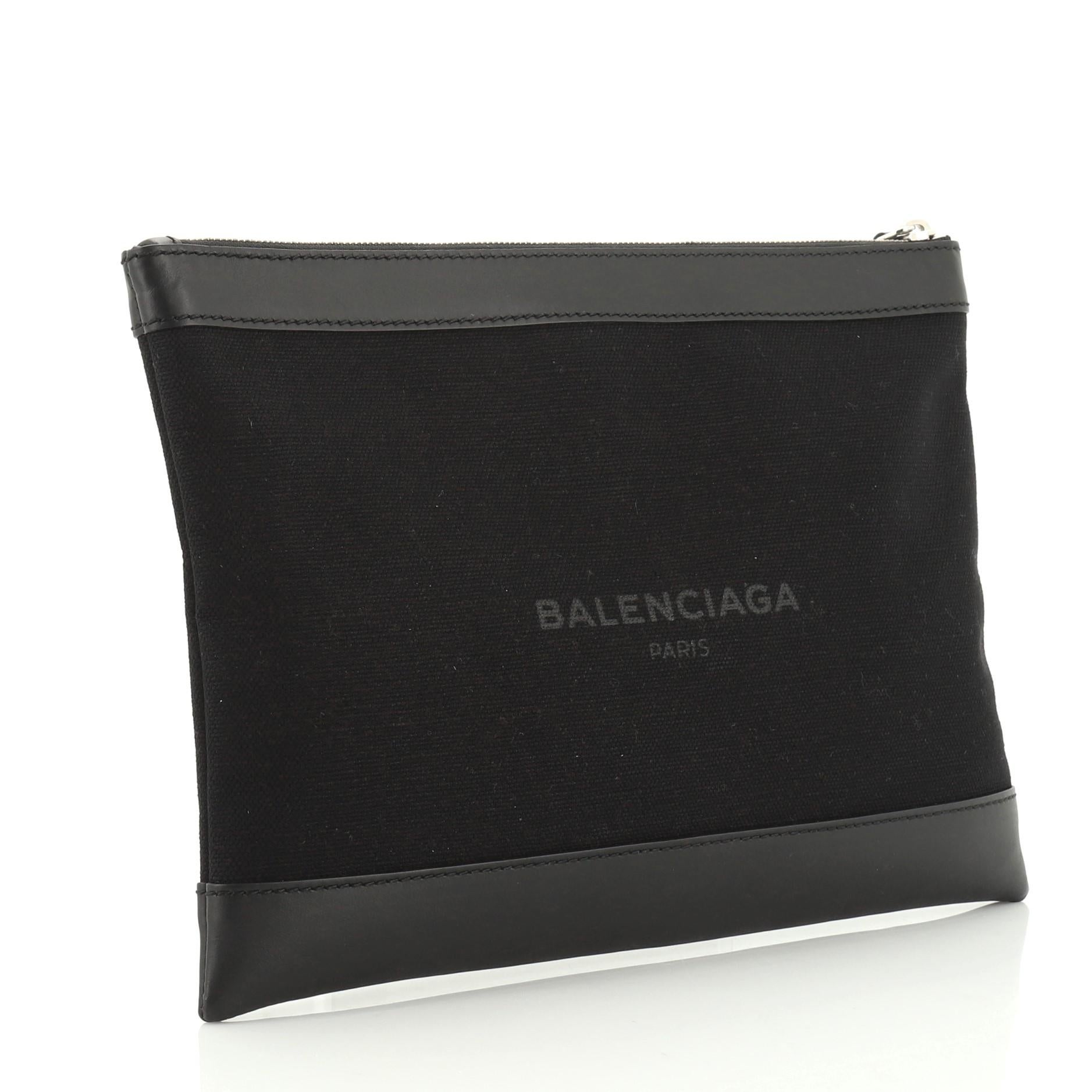 This Balenciaga Navy Zip Pouch Canvas and Leather Large, crafted from black coated canvas, features silver-tone hardware. Its zip closure opens to a black fabric interior with slip pocket. 

Condition: Excellent. Minor wear on base corners,