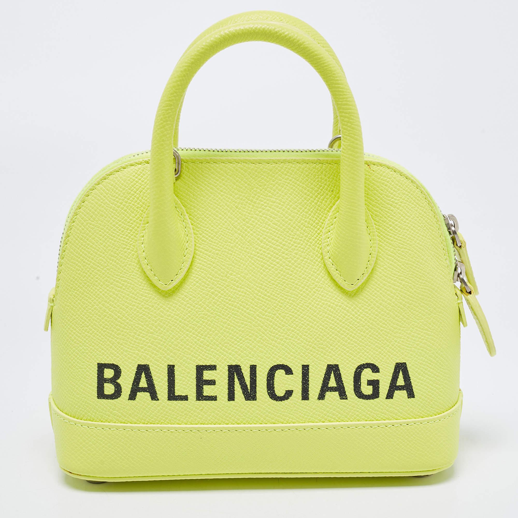 Defined by the signature on its exterior, Balenciaga's XXS Ville Logo satchel is an everyday showstopper. Shaped in a compact size, the silver-tone hardware and branding in black offer a luxurious contrast to the neon yellow leather. Secure the zip