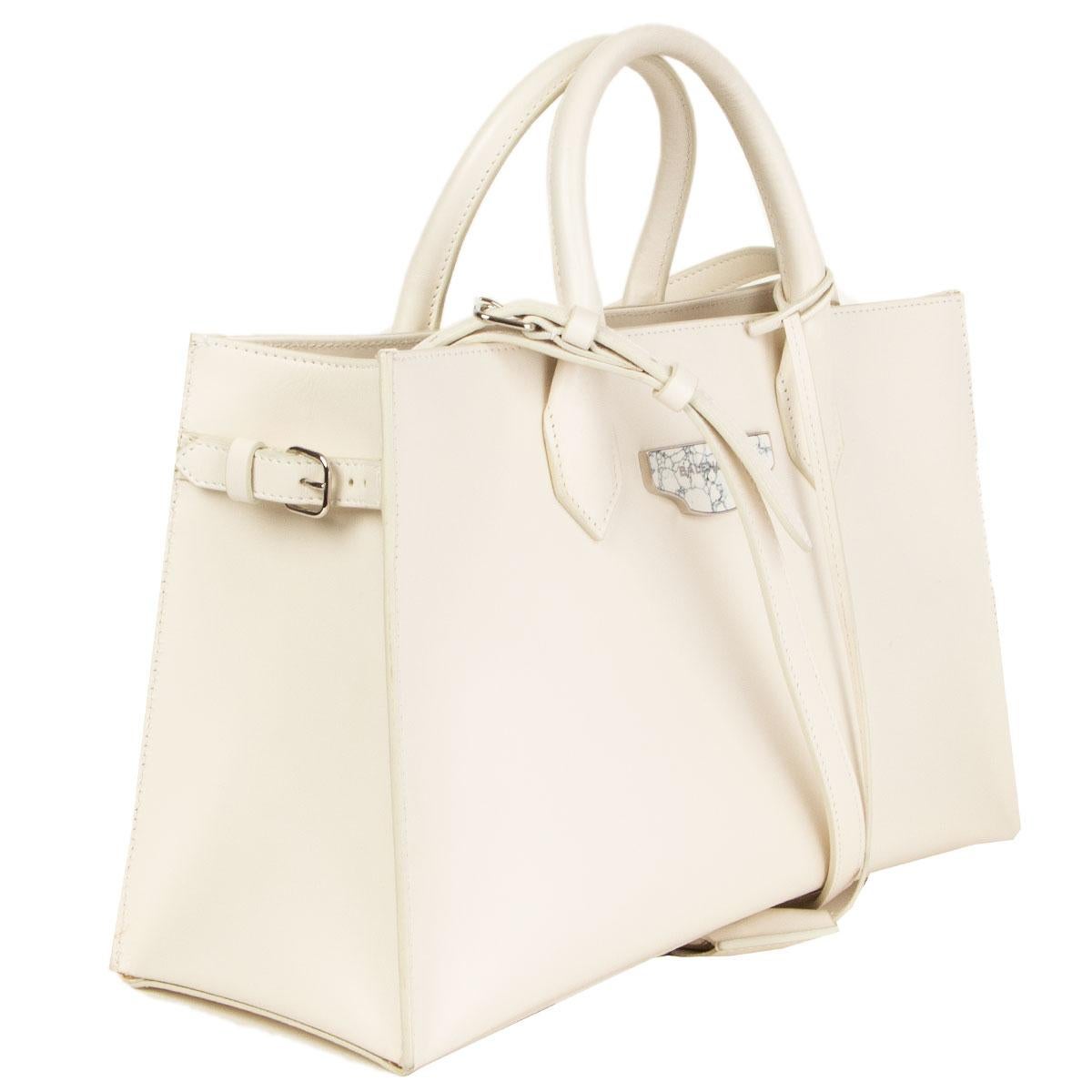 100% authentic Balenciaga tote bag in off-white leather comes with top handles, detachable and adjustable shoulder strap. Features buckle details at the sides. Has a zipped and a slot pocket including a detachable framed mirror on the inside. Lined