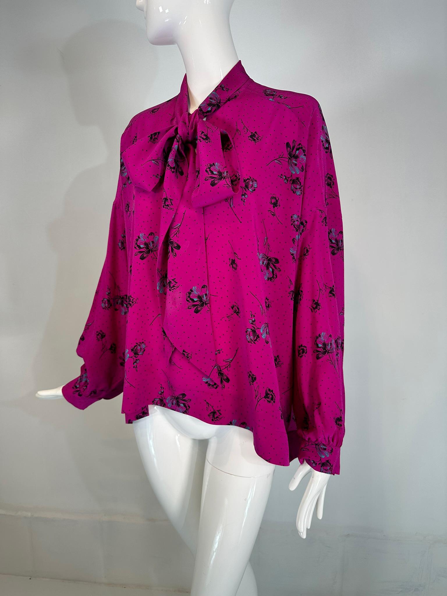 Blusa Balenciaga de crepé de seda con estampado rosa intenso, manga larga y lazo. Preciosa blusa para llevar con cinturón o con volumen y fluida. Blusa con abertura delantera, hombros caídos y mangas con puños abotonados. Cuello con lazo.
Dobladillo