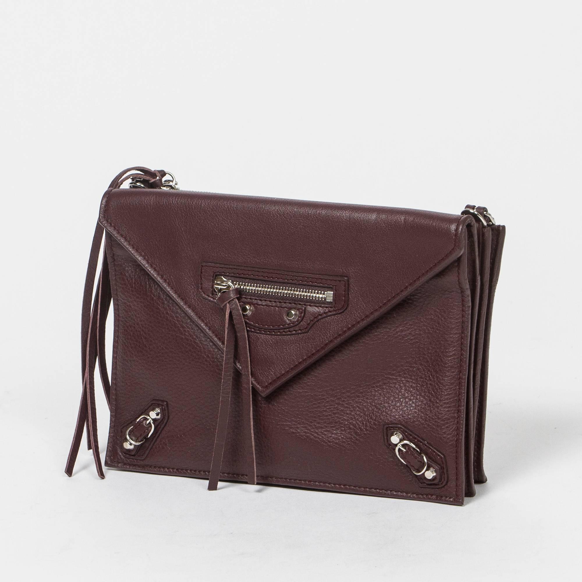 Paper Envelope Crossbody bag in brown leather with removable shoulder strap, silver tone hardware. Front pocket with magnetic closure. 4 compartment bag which 2 are zipped. One slip pocket in the last compartment. Production code 357321-6110-G-1669.
