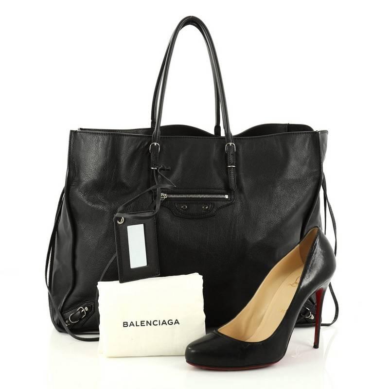 This authentic Balenciaga Papier A4 Zip Around Classic Studs Handbag Leather is a modern accessory perfect for everyday excursions. Crafted in black leather, this lightweight tote features slim handles, zip sides that allows the bag to expand, front