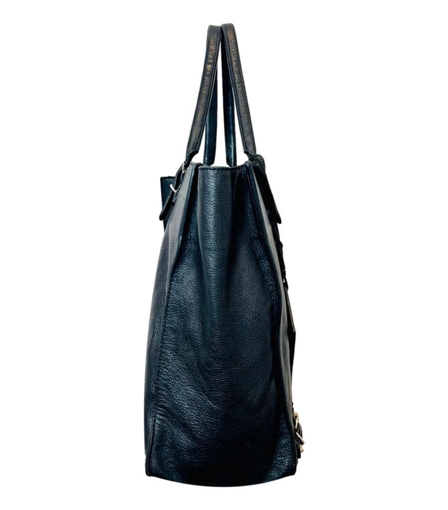 Balenciaga Papier Leather Tote Bag

Black shoulder bag styled with zipped pocket to the centre and buckle detailing to the corners.

Featuring adjustable dual top handle and zipped top leading to spacious interior.

Designed with silver hardware and