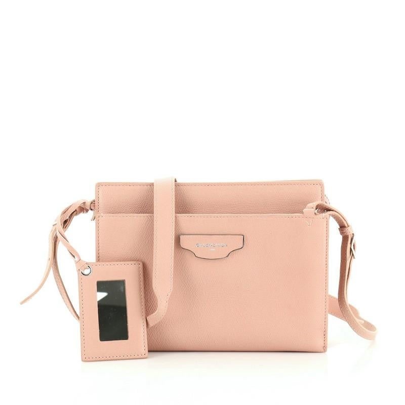 This Balenciaga Papier Plate Crossbody Leather, crafted in pink leather, features adjustable leather strap, exterior slip pockets with magnetic snap tab closure, and silver-tone hardware. Its top zip closure opens to a black fabric interior.