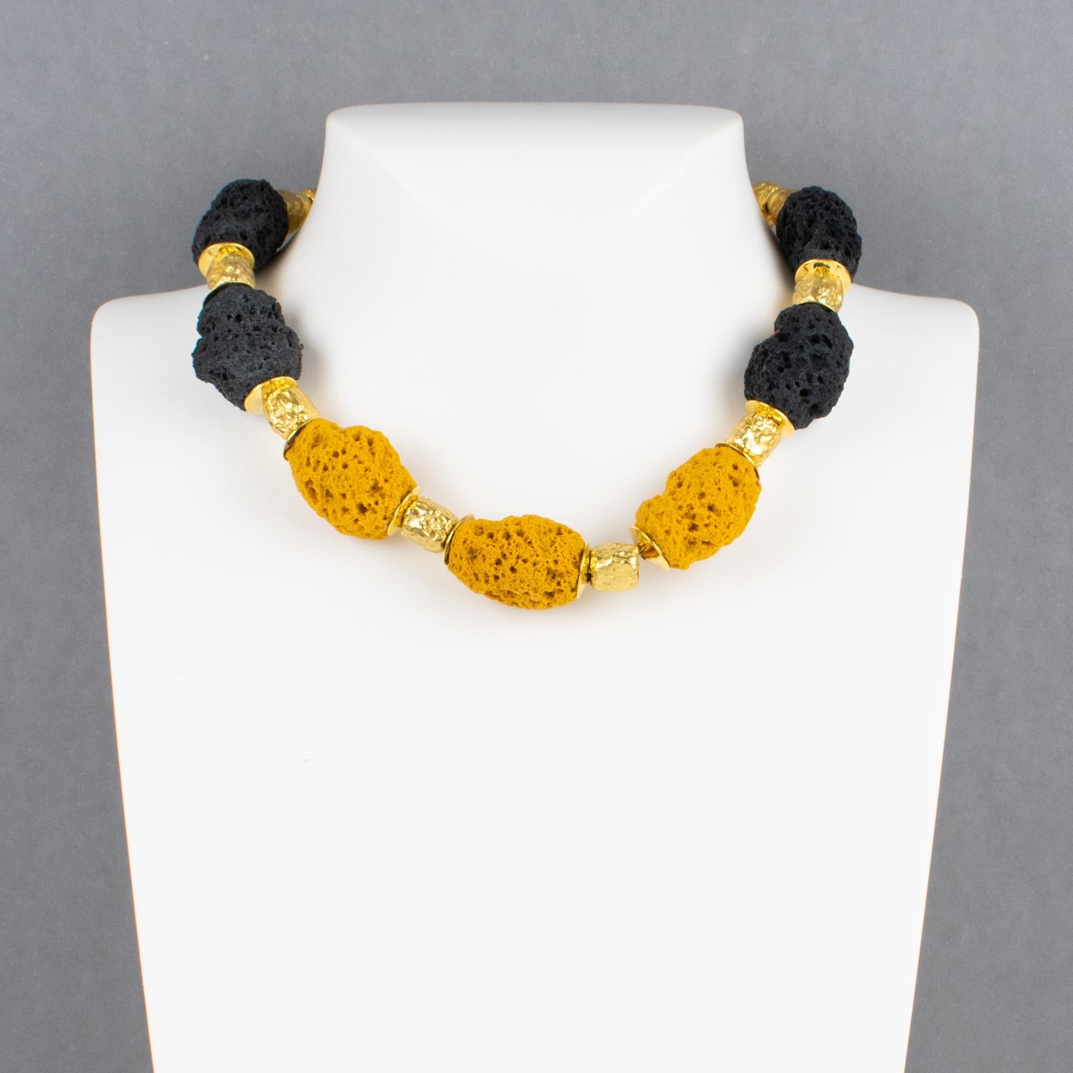 Questa elegante collana di Balenciaga Paris risale agli anni '80 e presenta un pesante girocollo di perline intagliate in metallo dorato, completate da perline in resina simile alla pietra lavica o alla spugna. Le perle di resina hanno colori neri e
