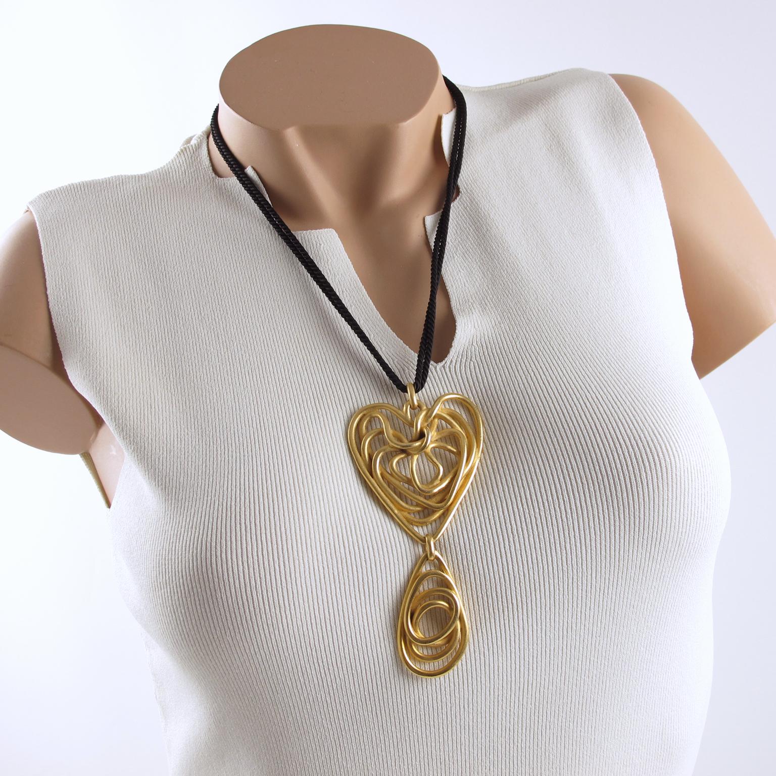 Elegant Balenciaga Paris signed pendant necklace. Massive gilt metal wired spiral design, articulated dangle shape with brushed finish aspect. Engraved signature at the back: 'Balenciaga Paris'. Long double strand black silk twisted chain with