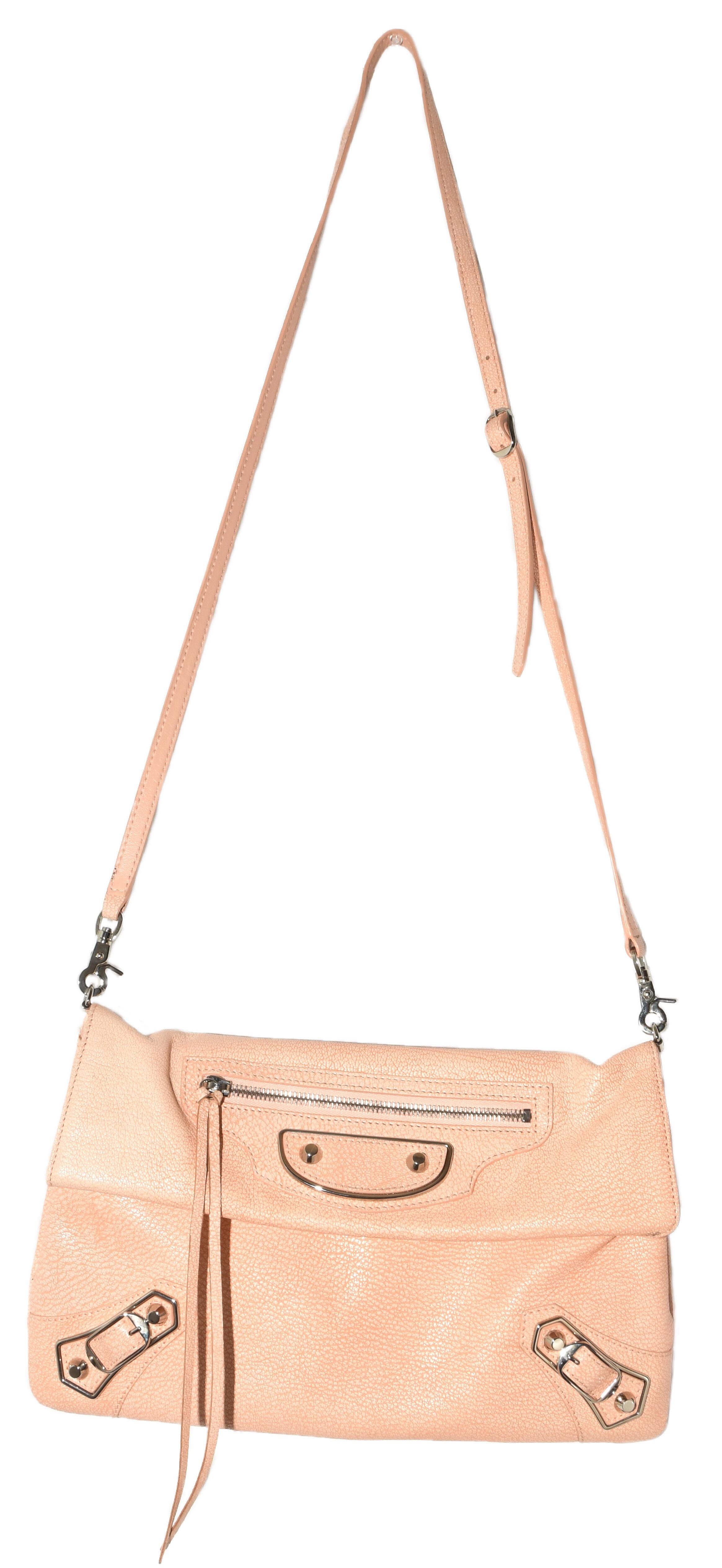 Balenciaga peach pebble leather City giant studs, features a removable shoulder strap.  An exterior front zip pocket at front, and rose gold-tone hardware.  Inside is a leather tag with a mirror.  This flap bag opens to a black fabric interior with