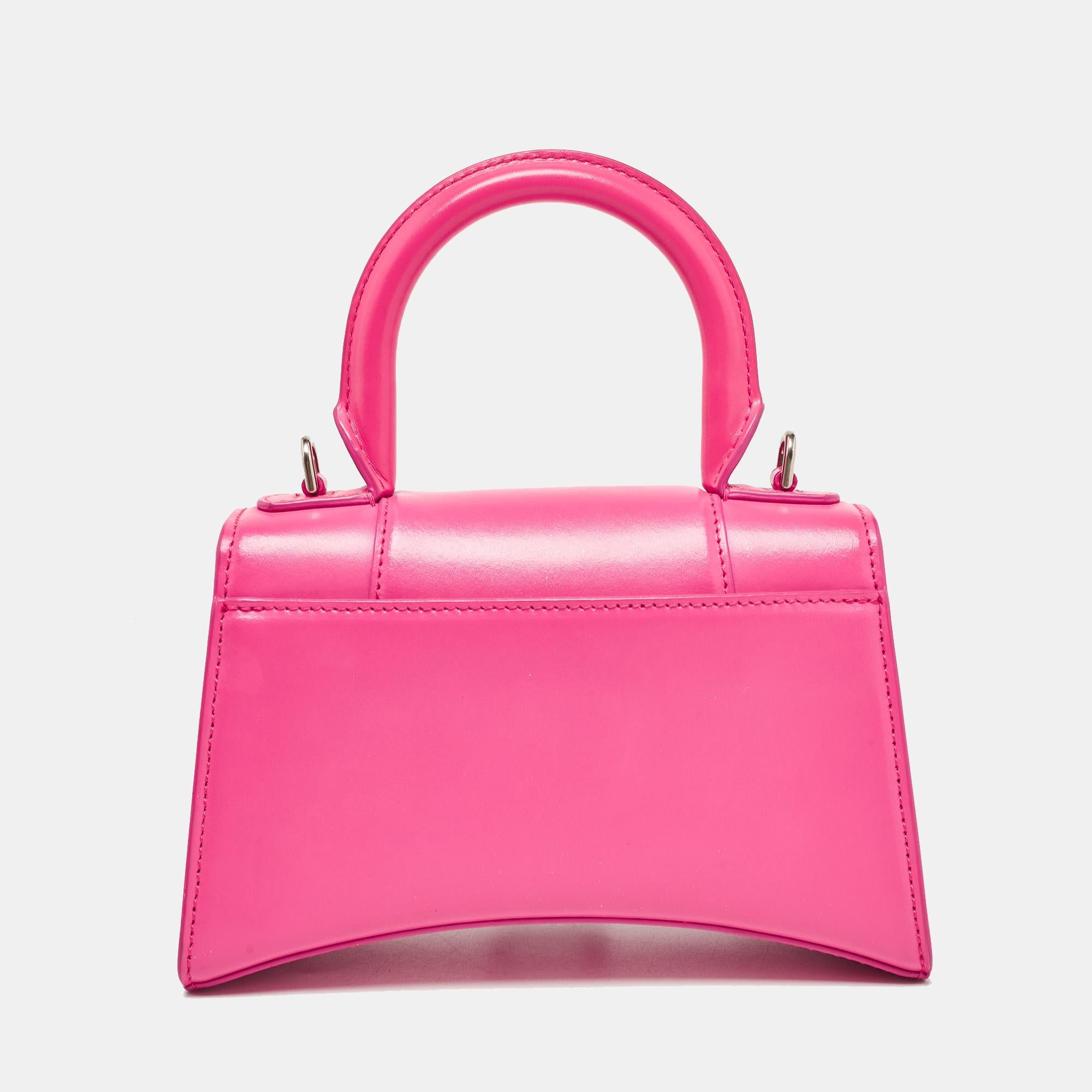 Balenciaga's Hourglass bag is fast becoming a must-have bag. Crafted using leather, the XS Hourglass top handle bag is styled with a flap that has the iconic B logo. The bag has a lined interior, a shapely top handle, and a shoulder
