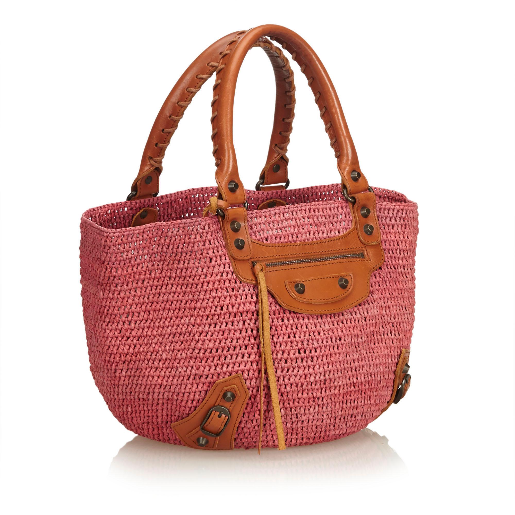 The Motocross Classic tote features a woven raffia body, rolled leather handles, open top, exterior zip pocket with a tassel zipper pull, and interior slip pockets. It carries as B+ condition rating.

Inclusions: 
This item does not come with