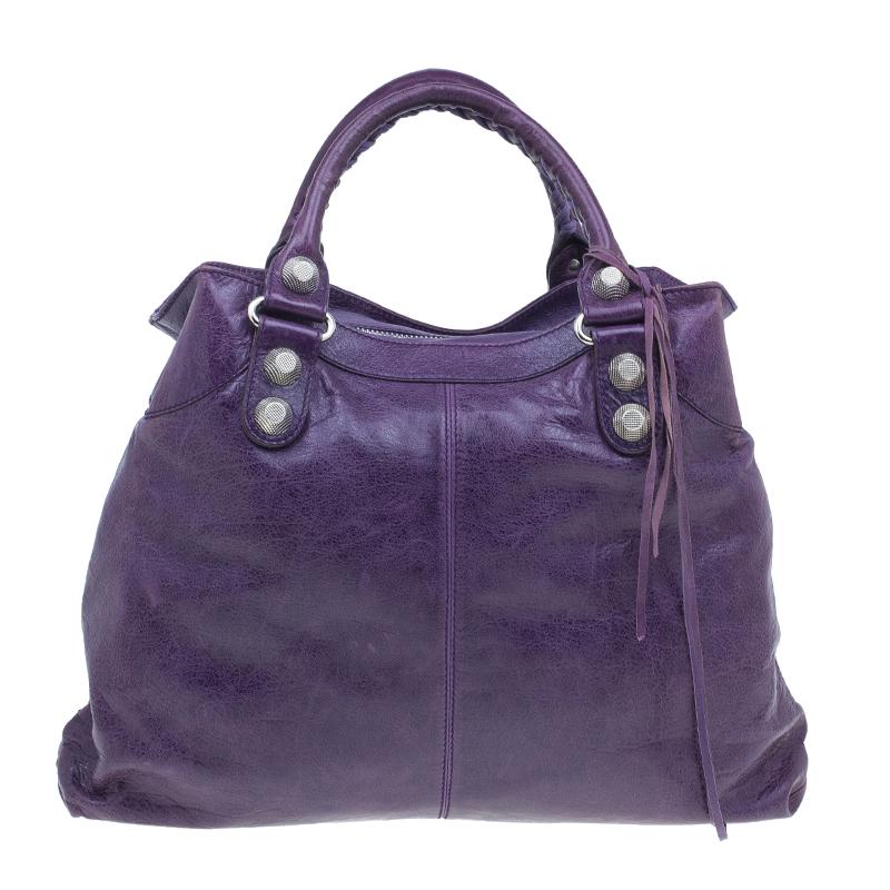 Carry this Arena Giant Brief bag with you everywhere you go. Crafted from distressed purple leather, this Balenciaga hobo is adorned with large silver-tone stud and buckle motifs. It has comfortable handles, an exterior zipped pocket and comes with
