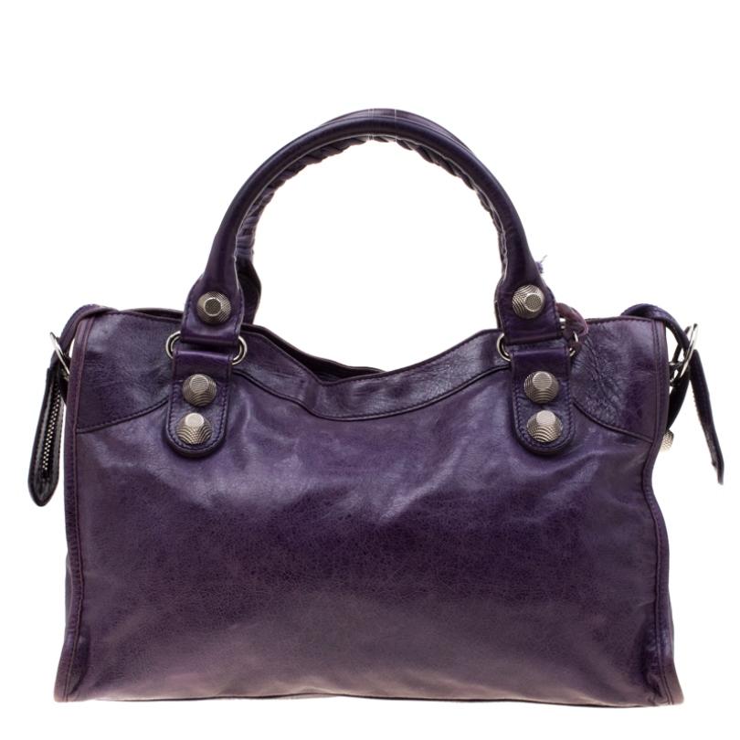 An elegant addition for your tote collection, this City bag from Balenciaga has an attractive exterior and slouchy body that exude a bold style making it a closet essential. Crafted from purple leather, the bag features dual top handles and giant