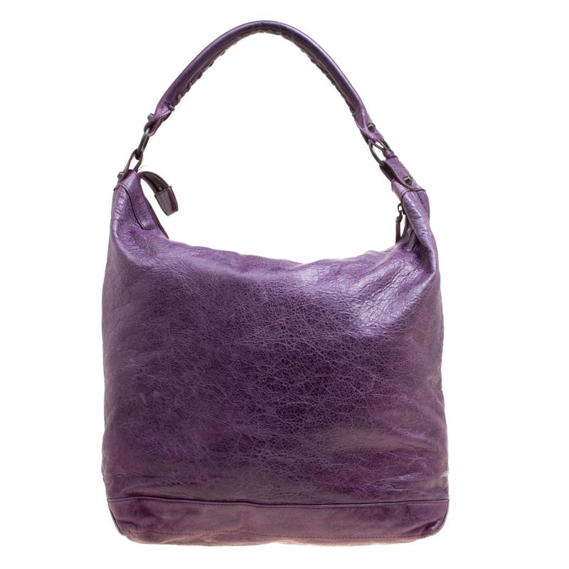 This Balenciaga classic day RH hobo is perfect for everyday use. Crafted from leather in a purple hue, the bag comes with a single handle and gold-tone hardware. The zip closure opens to a fabric lined interior and the bag is enhanced with buckle