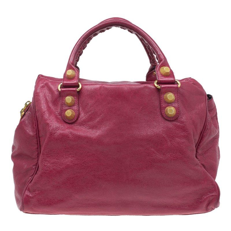 A popular bag among celebrities, this Giant 21 Midday bag by Balenciaga will never leave you unnoticed! It is crafted from red distressed lambskin leather and is accented with oversized signature metal buckle and stud details. It comes with a