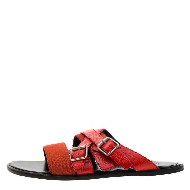 Comfort and style come together with these flat sandals from Balenciaga! These red slides are crafted from canvas and leather. They feature an open toe silhouette with broad cross straps on the vamps and come equipped with comfortable insoles. They