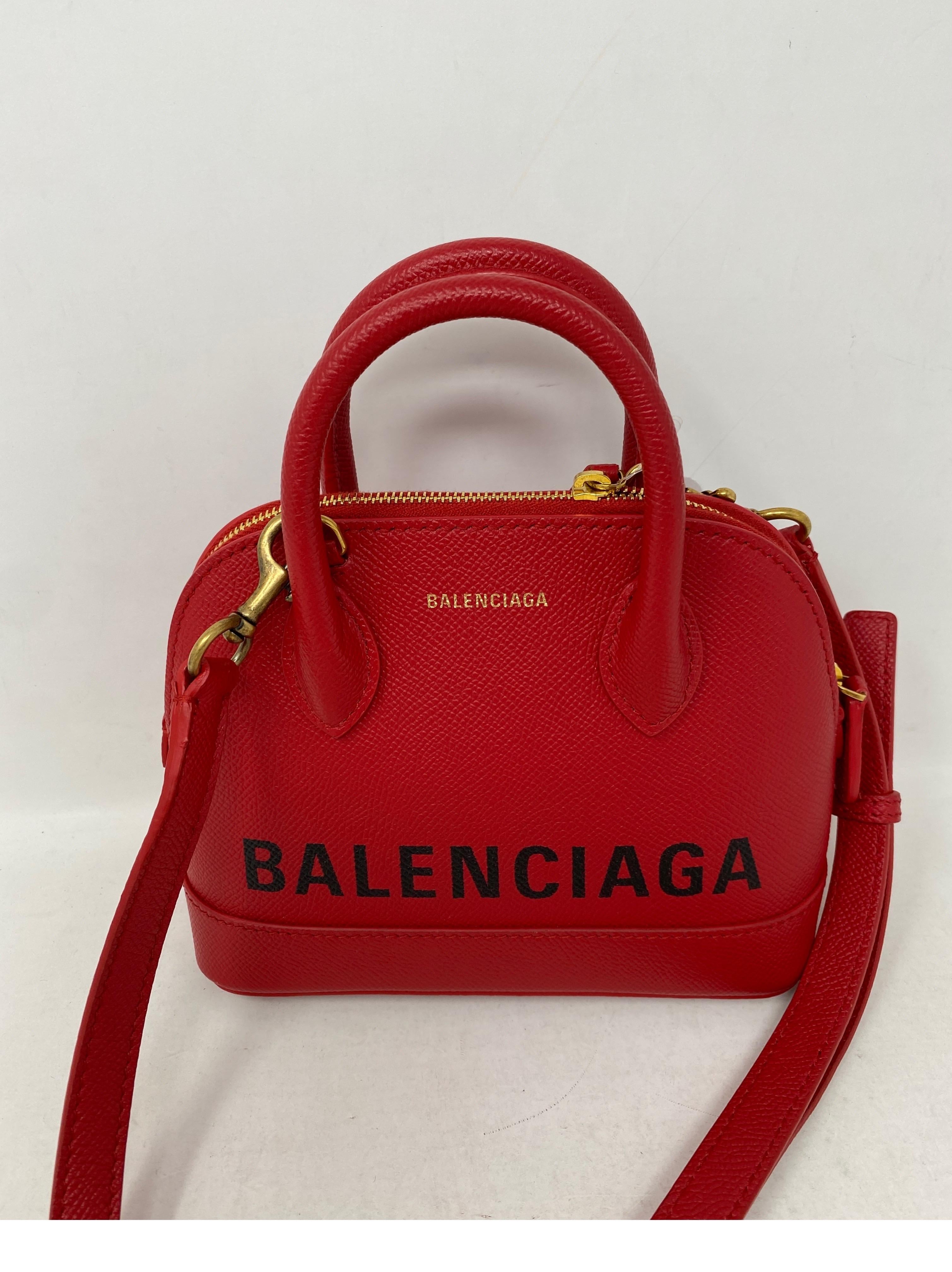Balenciaga Red Mini Top Handle Bag. Red leather wih Balenciaga lettering. Detachable strap. New condition. Very cute bag. Guaranteed authentic. 