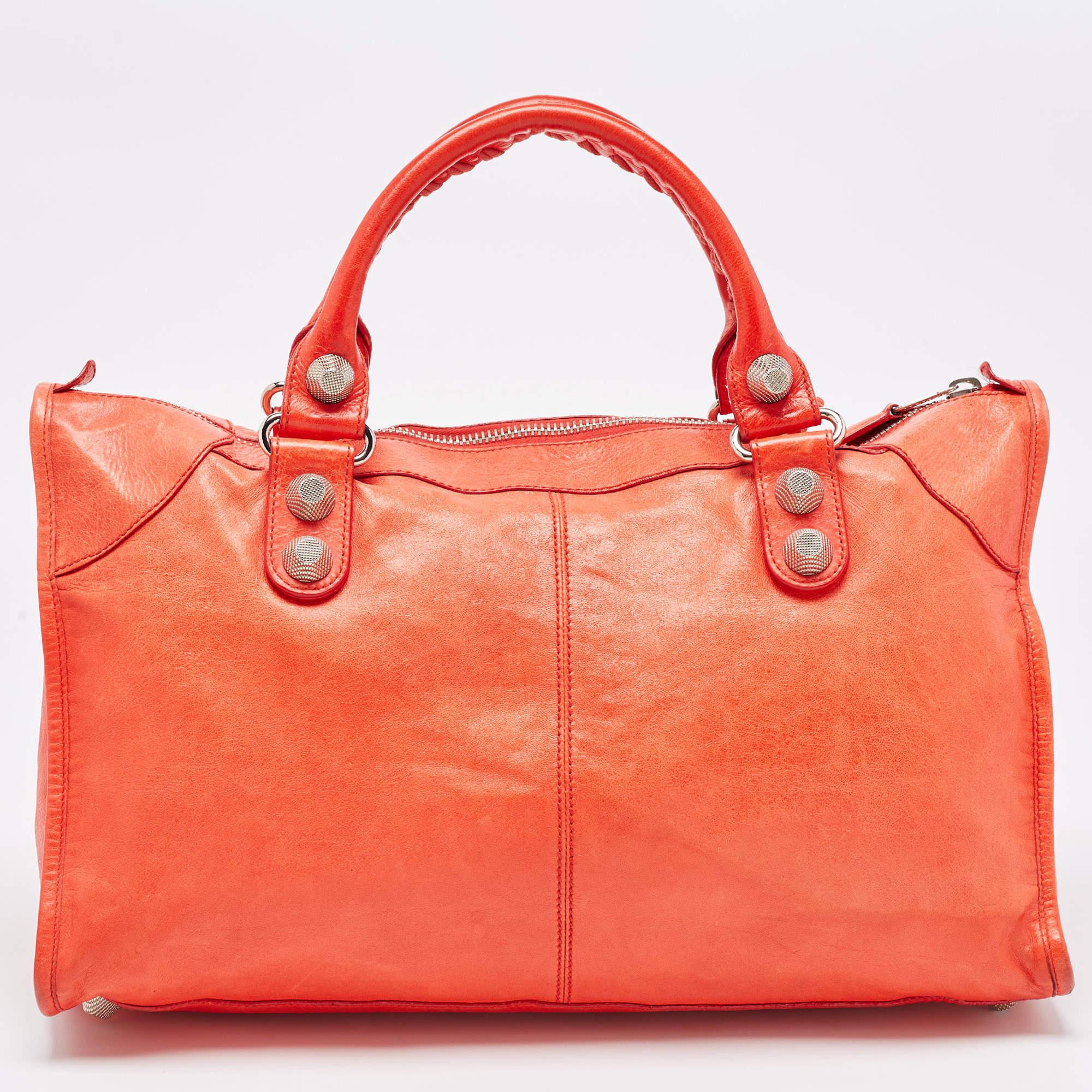 Revolutionary and visionary designs set Balenciaga apart from others, and this red creation testifies to it. The exterior of this tote is updated with chic and striking silver-tone accents. Crafted from leather, it is equipped with a front zipper
