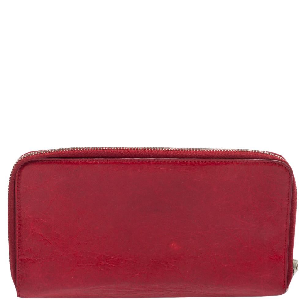This zip-around wallet certainly brings elegance and glamour to your style. Made with fine leather, this red wallet from Balenciaga proves to be super-chic and convenient for everyday use. A zipper pocket and silver-toned details are seen on the