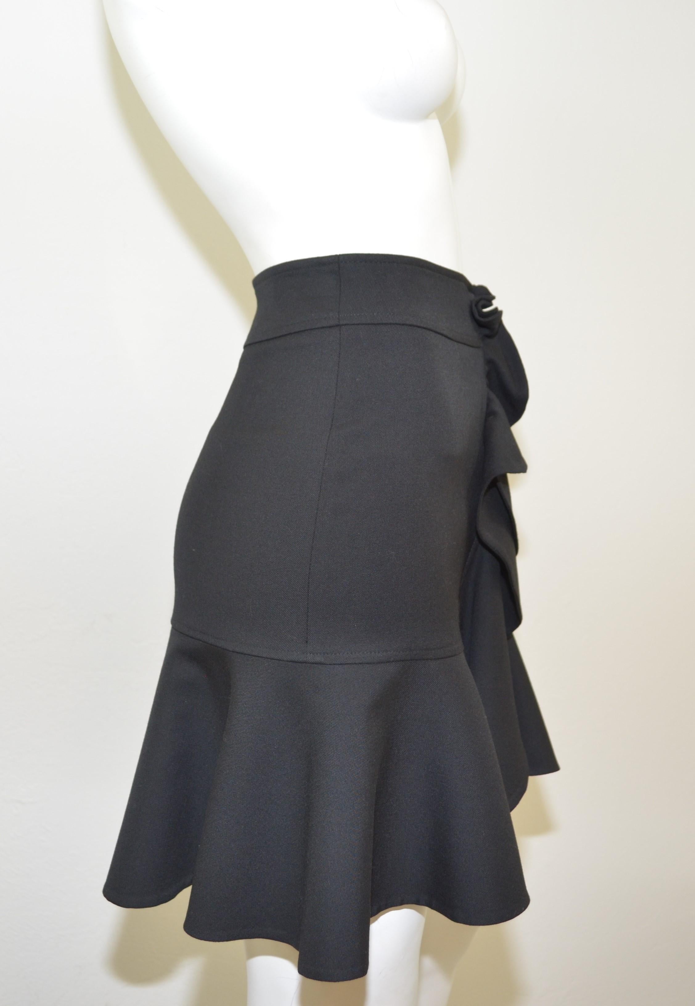 Balenciaga black mini skirt has a ruffled front detail and a fluted/flared hem with a side zipper closure. Skirt is a size 38, made in Italy. 99% wool & 1% silk.

Waist 28''
Hips 34''
Length 19''