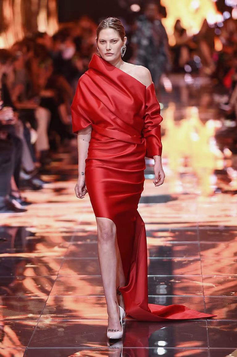 From Bergdorf Goodman Balenciaga rich red double matte satin gown.  Designed with a structural asymmetric high fashion flair.  Boasts a one-shoulder neckline. Long ruched sleeve. Origami folded bodice. Sheath silhouette. Draped cape back  One of the