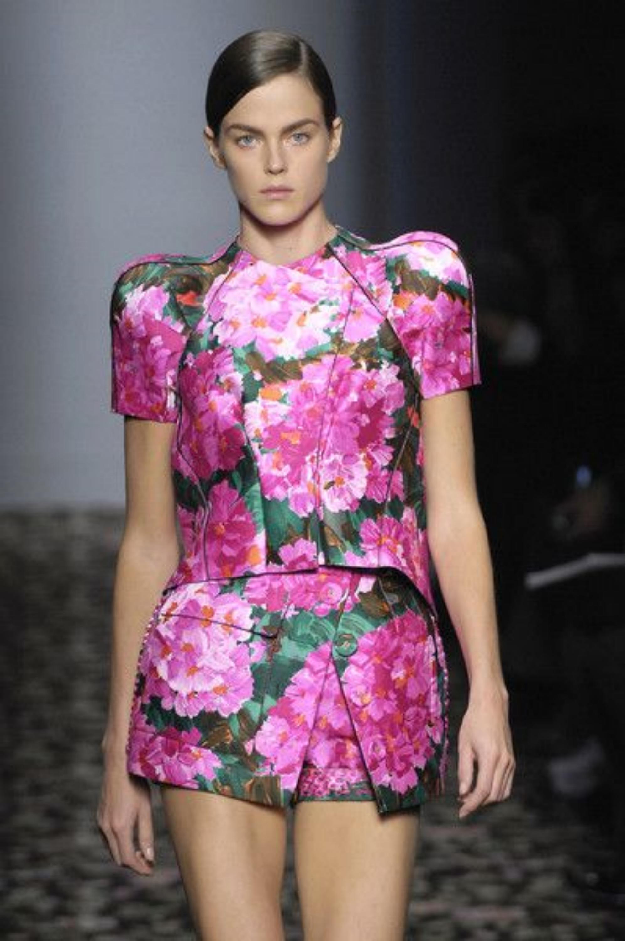 Questo pezzo iconico della collezione primavera/estate 2008 di Balenciaga, disegnato sotto la direzione creativa di Nicolas Ghesquière, incarna un'audace fusione di femminilità romantica e innovazione strutturale d'avanguardia. La silhouette senza