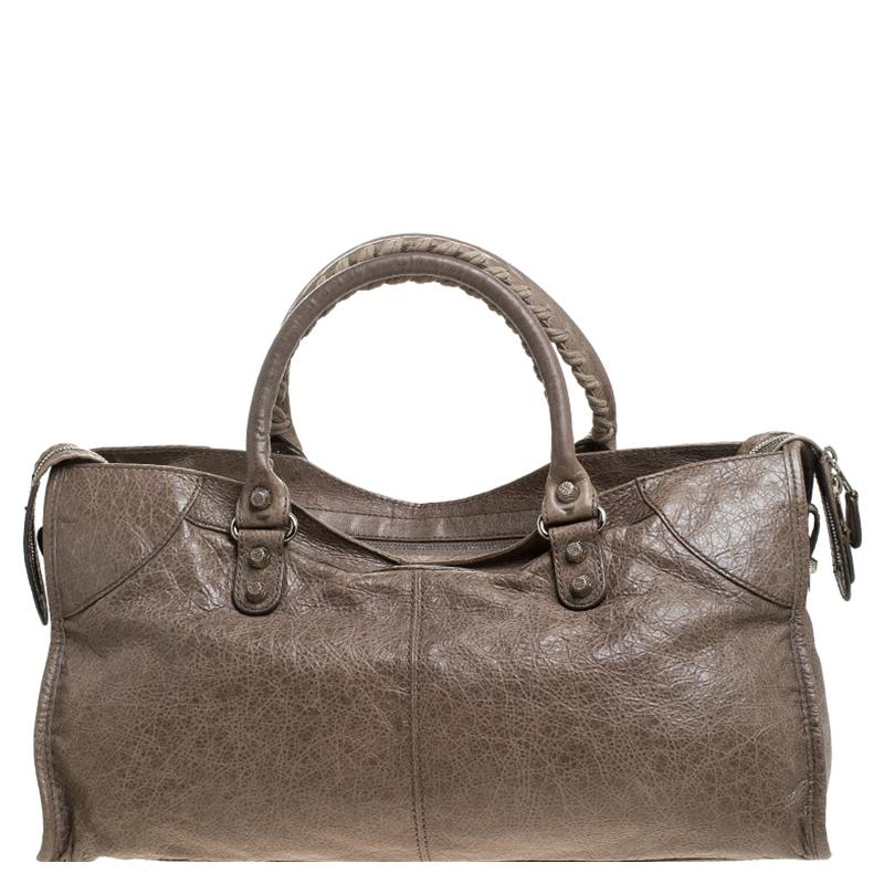 This Balenciaga Part Time tote is perfect for everyday use. Crafted from leather in a gorgeous sandstone hue, the bag has a feminine silhouette with two top handles, a removable shoulder strap, and silver-tone hardware. The zipper closure opens to a