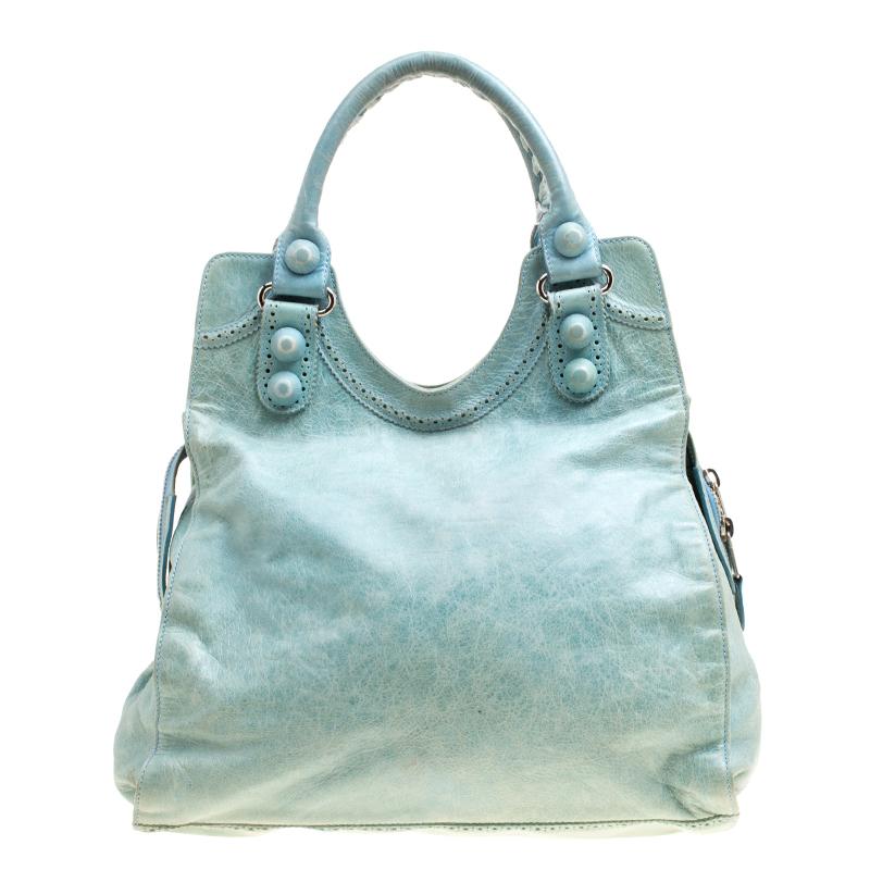 This Balenciaga Folder tote is perfect for everyday use. Crafted from leather in a gorgeous sea green hue, the bag has Brogues detailing on the exterior. The dual zip closure opens to a fabric lined interior that will hold all your belongings. The