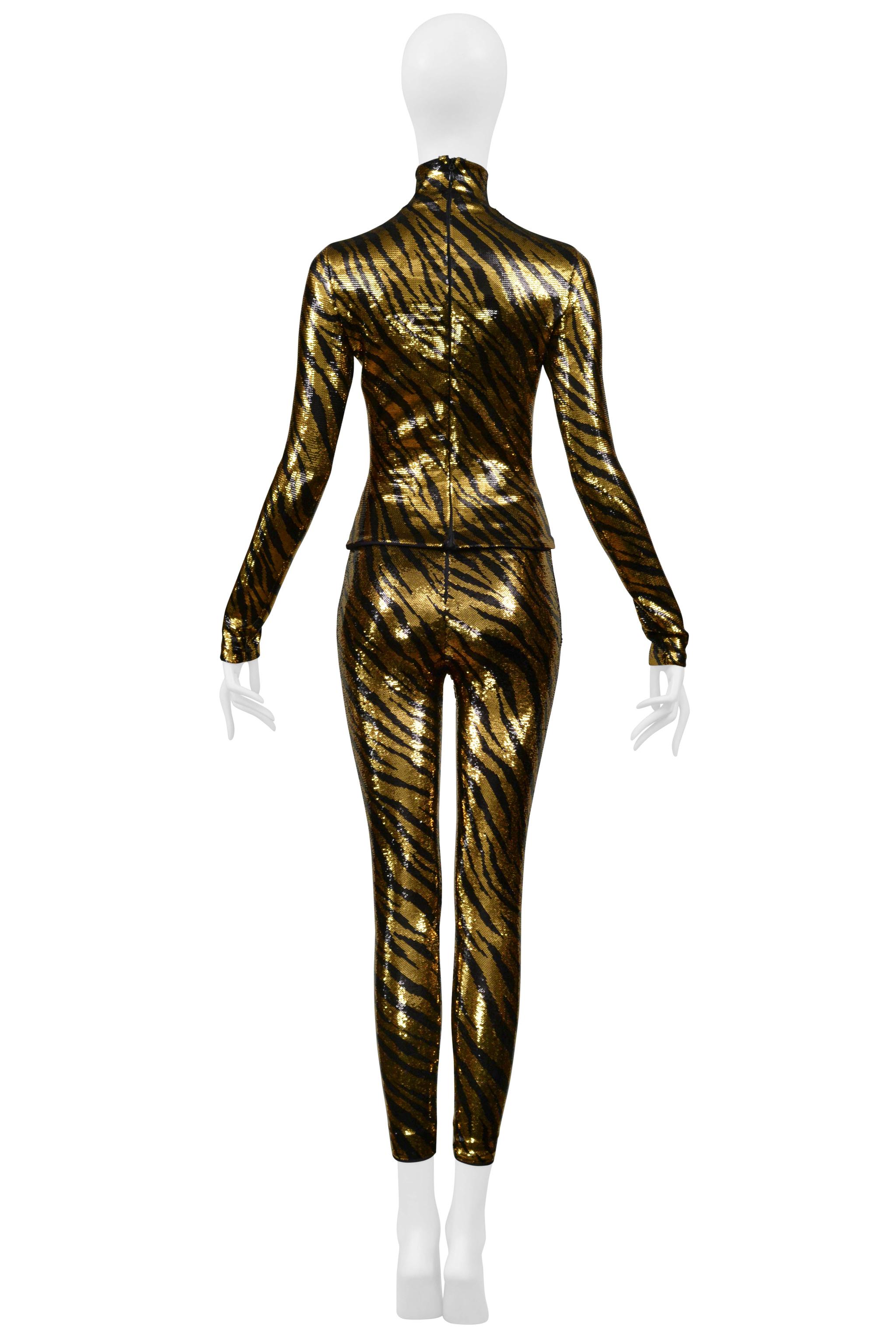 Resurrection Vintage se complace en presentar un conjunto de lentejuelas de rayas de tigre naranjas y negras de Balenciaga by Demna Gvasalia. El top presenta cuello de tortuga, mangas largas, silueta entallada y cremallera trasera oculta. Los