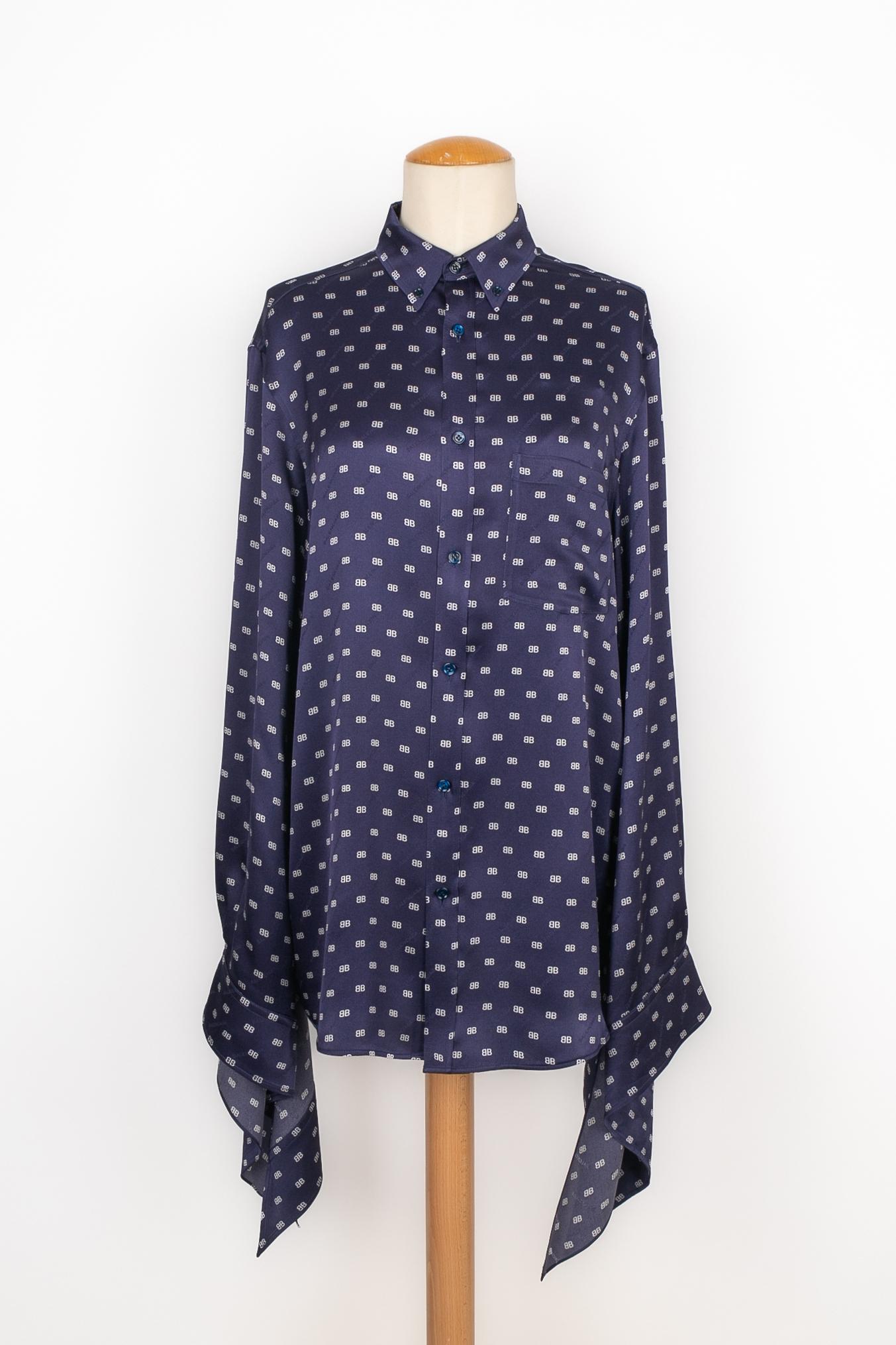 BALENCIAGA - Camicia in seta blu stampata con monogrammi bianchi. Indicata la taglia 38FR.

Condizioni:
Ottime condizioni

Dimensioni:
Larghezza spalle: 48 cm - Petto: 55 cm - Lunghezza maniche: 70 cm - Lunghezza: 75 cm

SKU:FH42