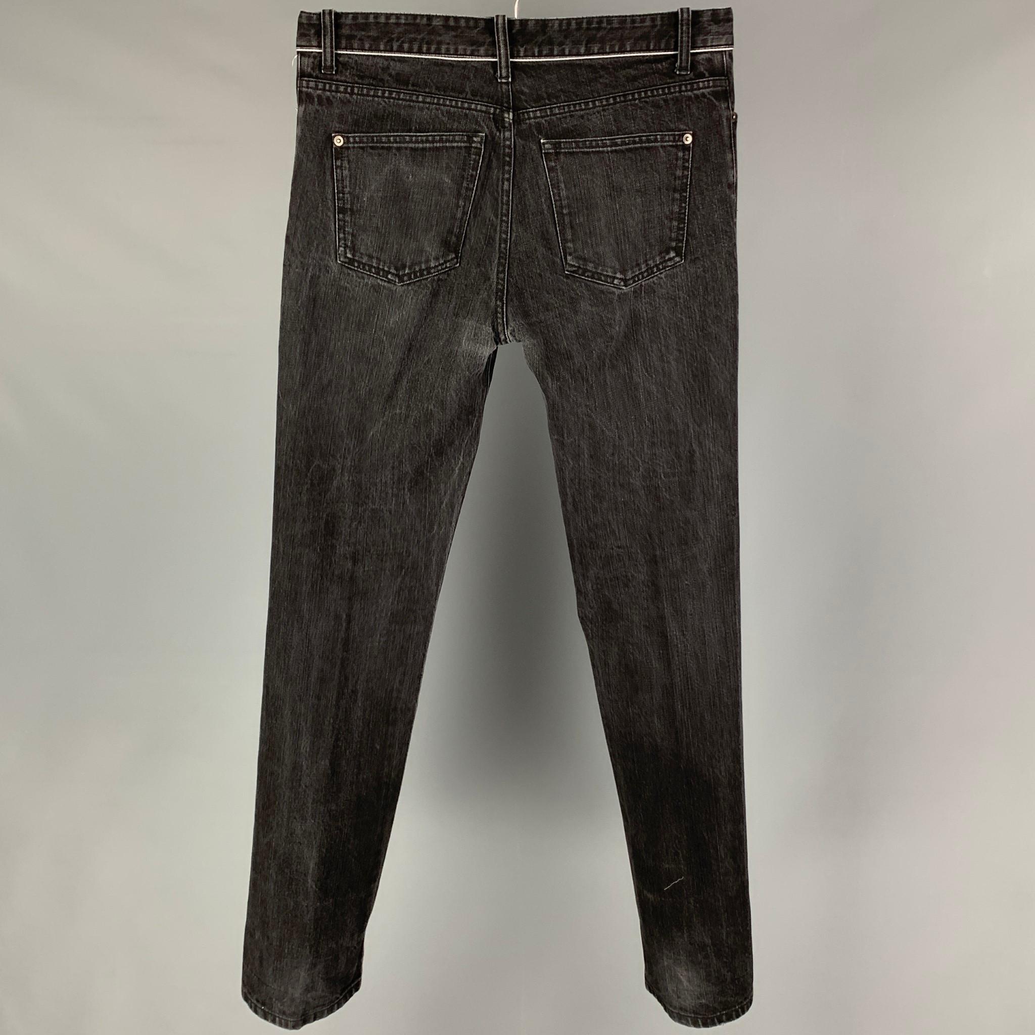 BALENCIAGA jeans comes in a black washed denim featuring a slim fit, white trim, and a button fly closure. Made in Italy. 

Very Good Pre-Owned Condition.
Marked: 33

Measurements:

Waist: 34 in.
Rise: 11 in.
Inseam: 35 in.