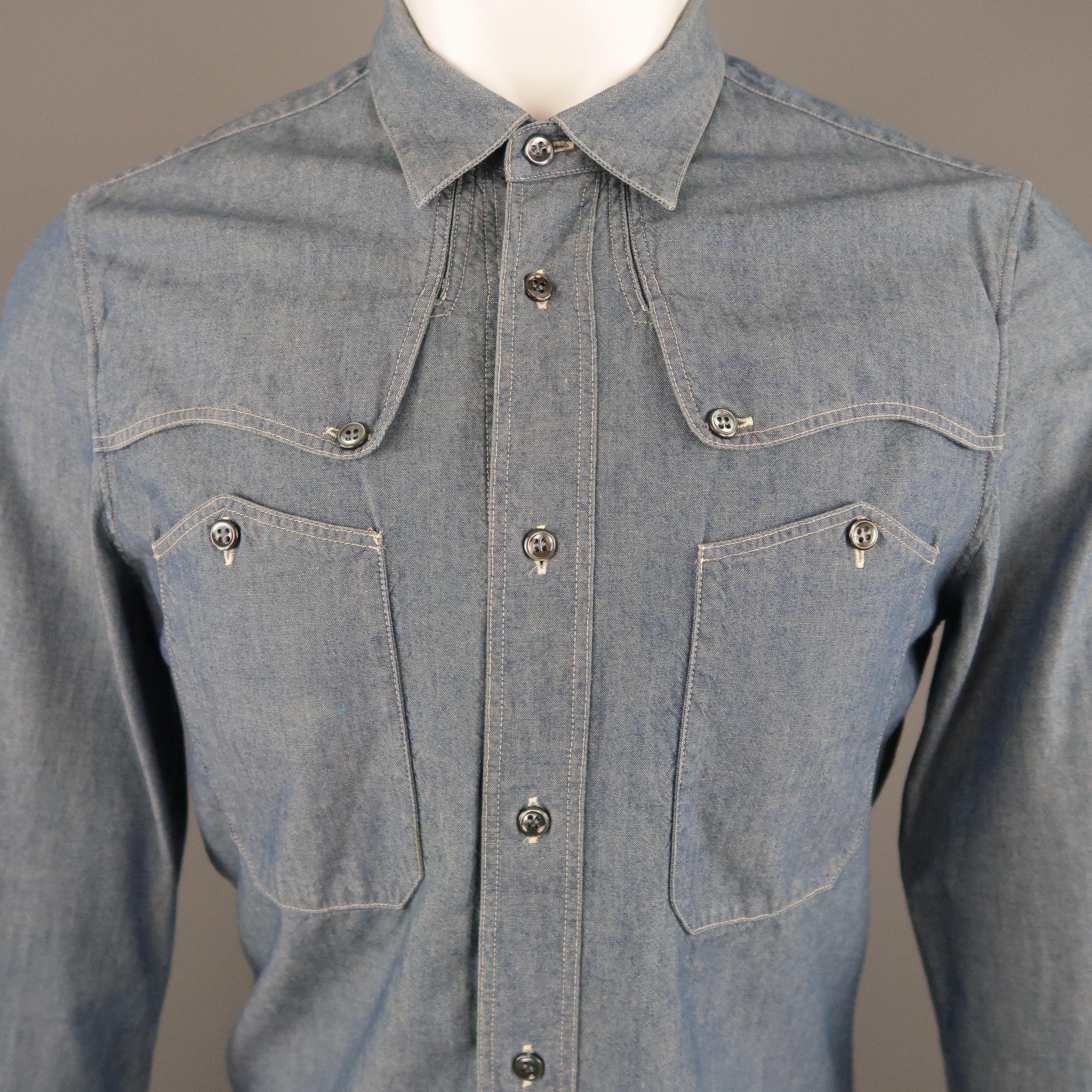 BALENCIAGA button up comes in blue chambray with a pointed collar, shoulder overlay, patch button chest pockets, and patchwork back. Spots on chest and sleeve and minor wear around collar. As-is. Made in Italy.
 
Good Pre-Owned Condition.
Marked: