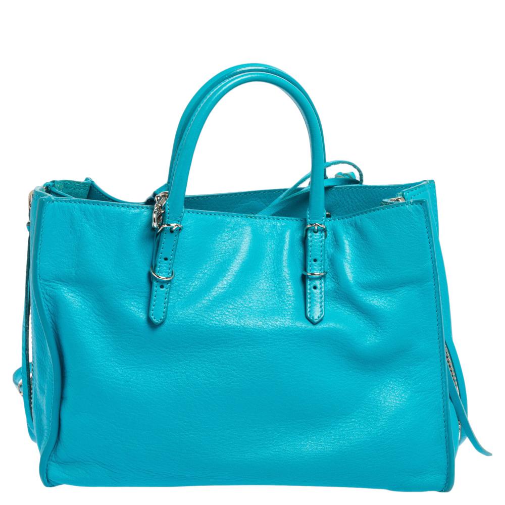 Papier A6 tote from Balenciaga smoothly blends luxury with practical fashion. It comes crafted from quality leather into a structured body and styled with two top handles and a spacious interior. But it is the zippers and buckle detailing which