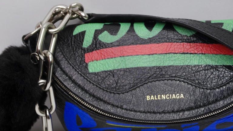 Feel the coolest in this street-wear inspired handbag from the iconic Balenciaga! Everyone will be wondering where they can get this rare gem. This bag is crafted of black lambskin leather with Balenciaga graffiti-inspired print in vibrant colors.