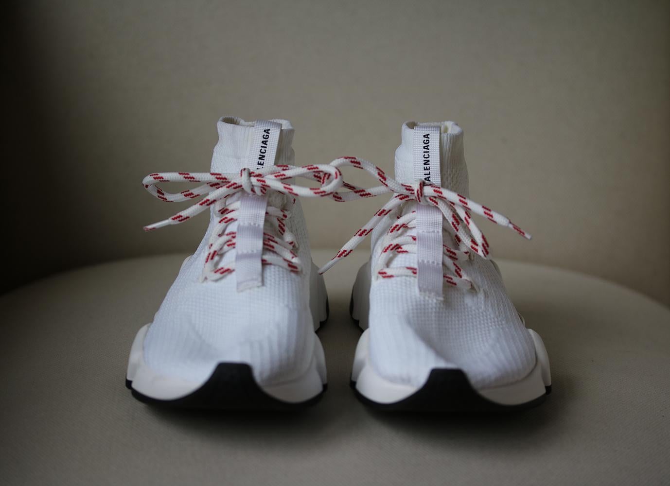 Balenciaga's 'Speed' sneakers have memory foam soles that weigh as little as eight and a half ounces to recreate the feeling of walking on air. This pair is made from flexible white stretch-knit and has contrasting red laces. Sole measures