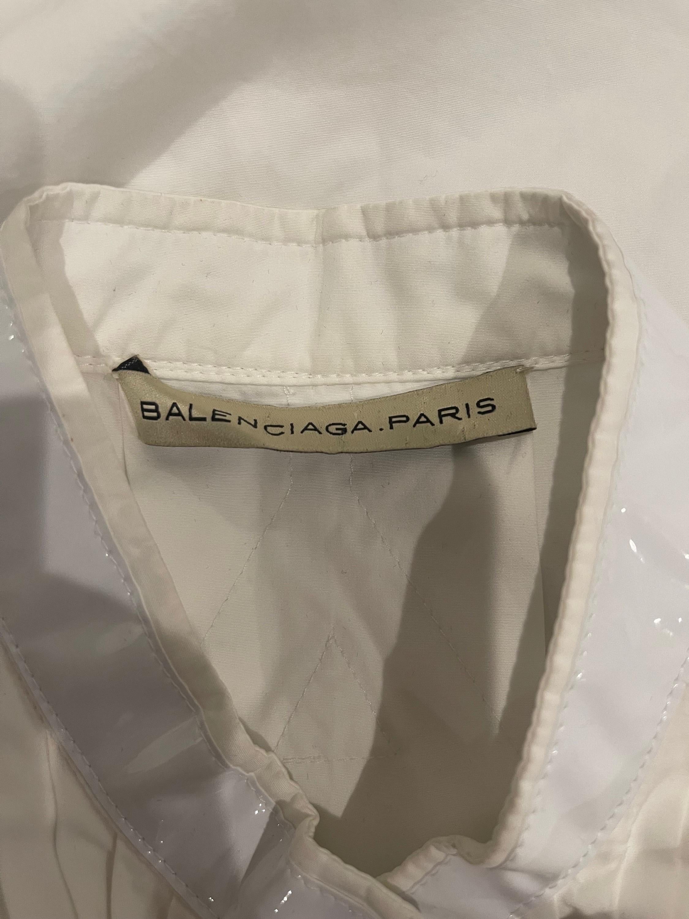 BALENCIAGA by NICOLAS GHESQUIERE Spring 2007 Runway white tuxedo shirt dress ! Cotton with white vinyl trim. Hidden buttons up the front. Can be worn a variety of ways, including as an open vest. Adjustable buttons at side hips.
In great unworn