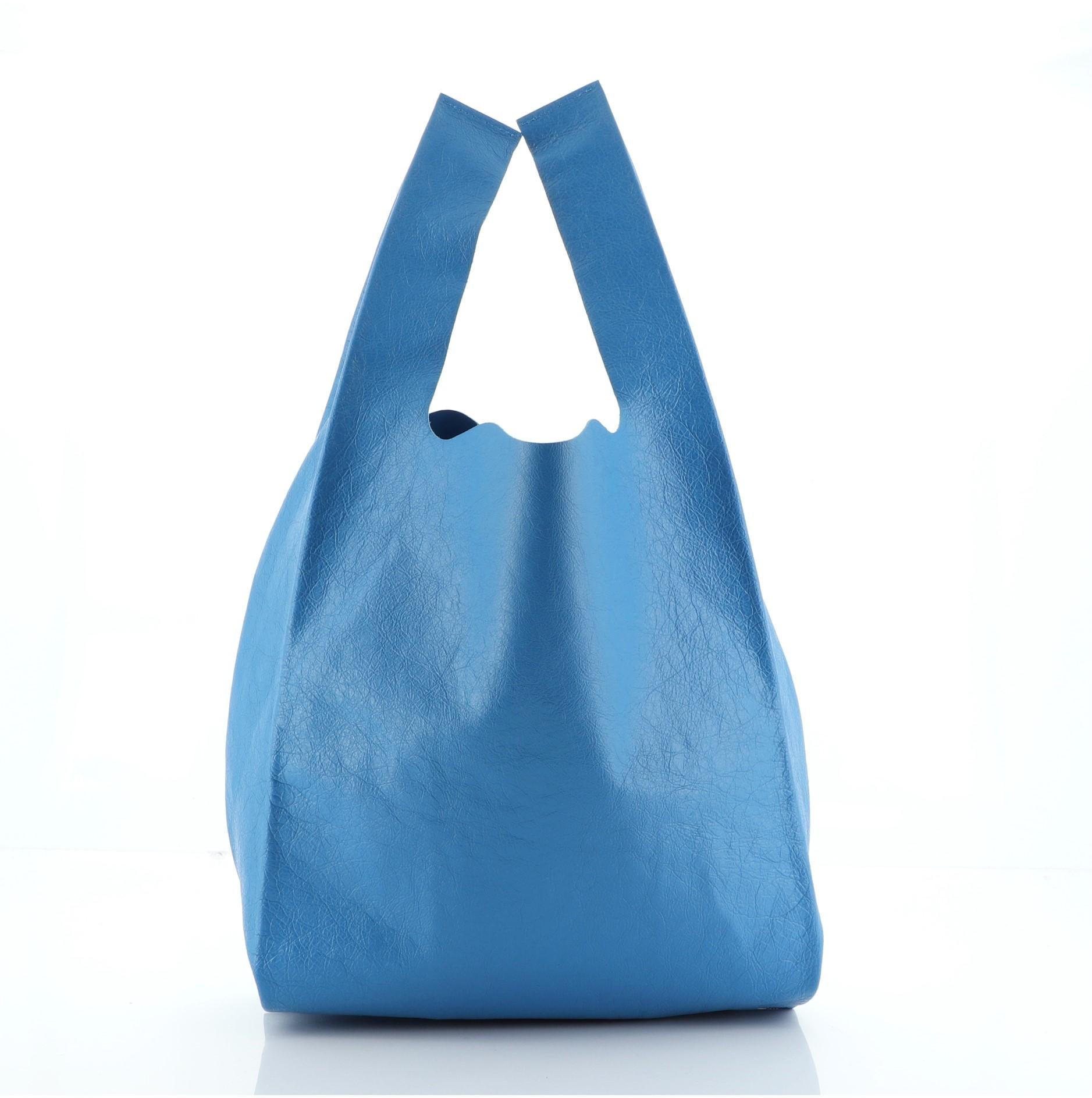 Balenciaga Supermarket Shopper Bag Printed Leather Small
Blue Leather

Condition Details: Minor wear on base corners, light scuffs and wear on exterior and in interior.

45020MSC

Height 15
