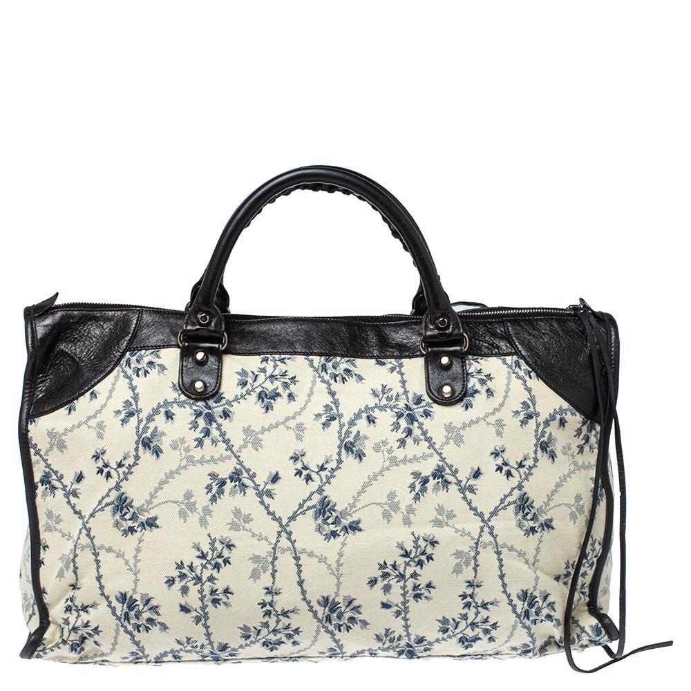 This Balenciaga RH work tote is perfect for everyday use. Crafted from floral-print canvas and leather in three different hues, the bag has a feminine silhouette with two top handles and silver-tone hardware. The zipper closure opens to a