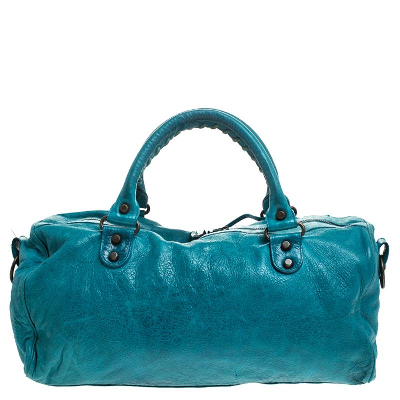 This turquoise tote by Balenciaga will elevate your day look. Made from leather, its front features the iconic Balenciaga studs and buckle motifs, in addition to a front zipped pocket for essentials. The double top handles are coupled with a