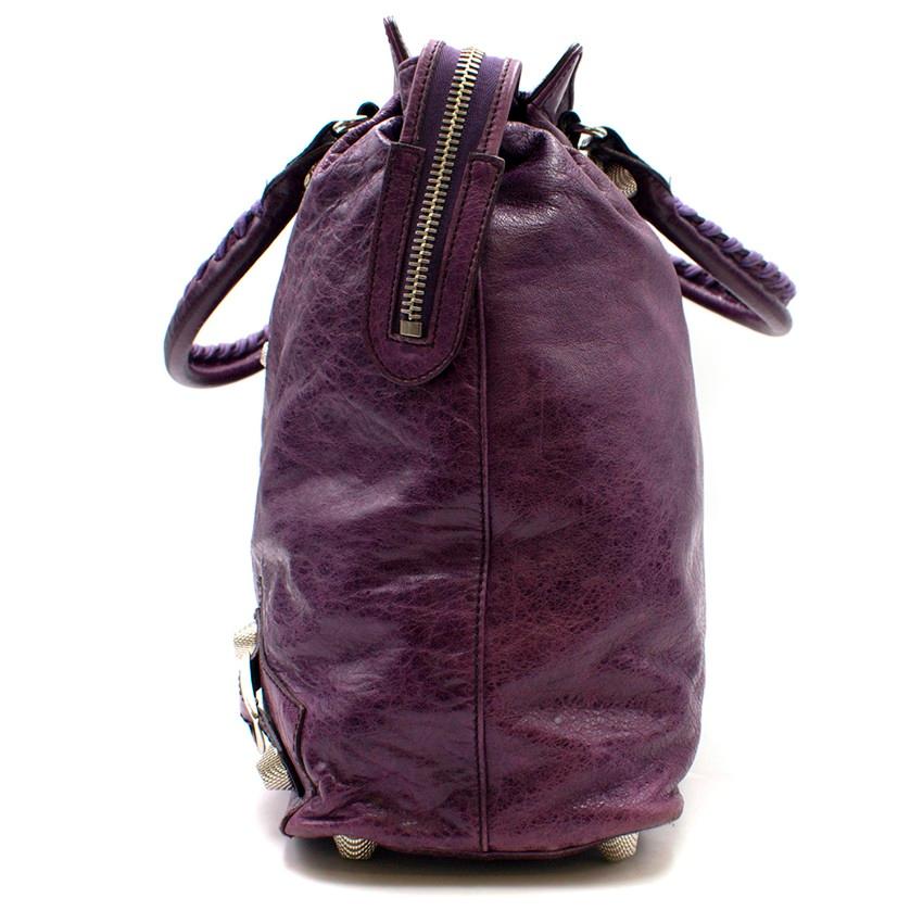 Balenciaga Velo Giant Studs Tote Bag

- Double shoulder straps with woven cord detail and large silver-tone thimble style studs 
- Slouchy hobo bag style
- Soft, distressed purple leather
- Decorative buckles and thimble studs in a mirrored style in