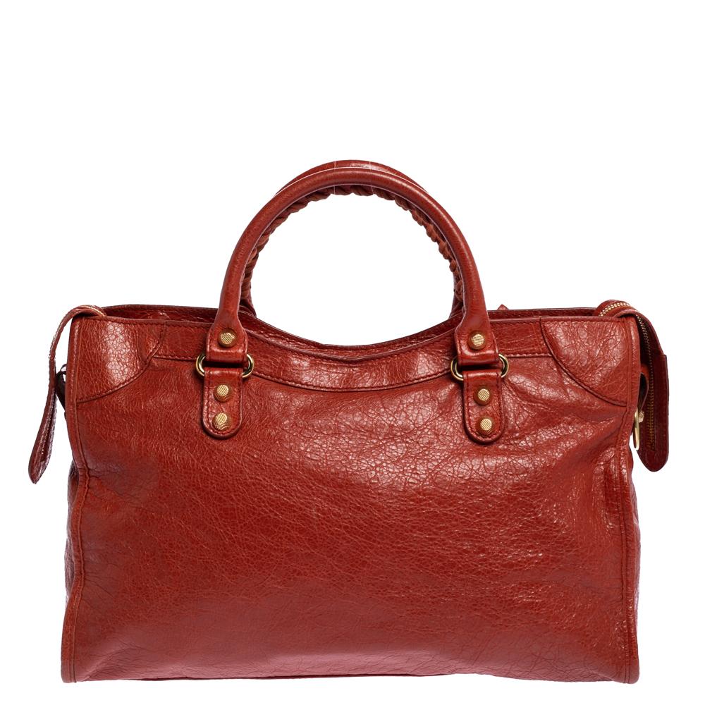 Balenciaga is known for its finely made products and the City bags are one of them. Effortless and stylish, this leather bag will be your go-to for multiple occasions. It has the signature details of buckles, studs and the front zipper. Two top