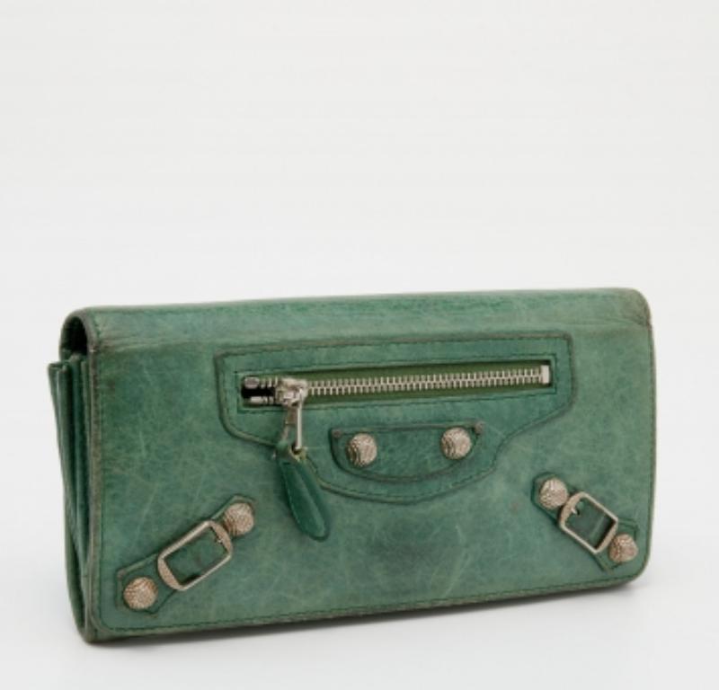 The silver-tone studs decorate the leather exterior of this Balenciaga wallet. It flaunts a front zipper pocket, and its fabric-lined interior is divided into different compartments to dutifully hold your monetary essentials.