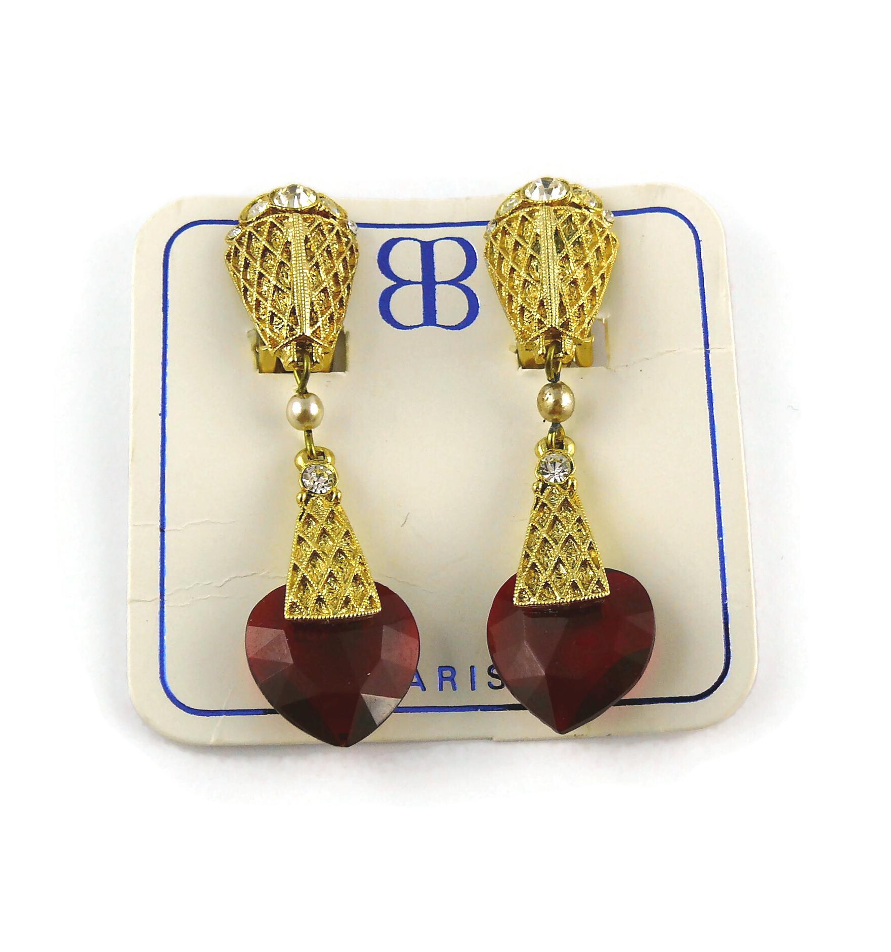 BALENCIAGA vintage gold toned dangling earrings (clip-on) earrings featuring a ruby red facetted glass heart drop, faux pearl and clear crystals.

Embossed with the monogram BB PARIS.

Indicative measurements : height approx. 5.9 cm (2.32 inches) /